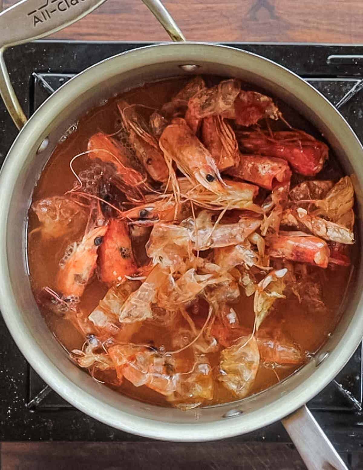 Cooking shrimp heads in water to make shrimp stock. 