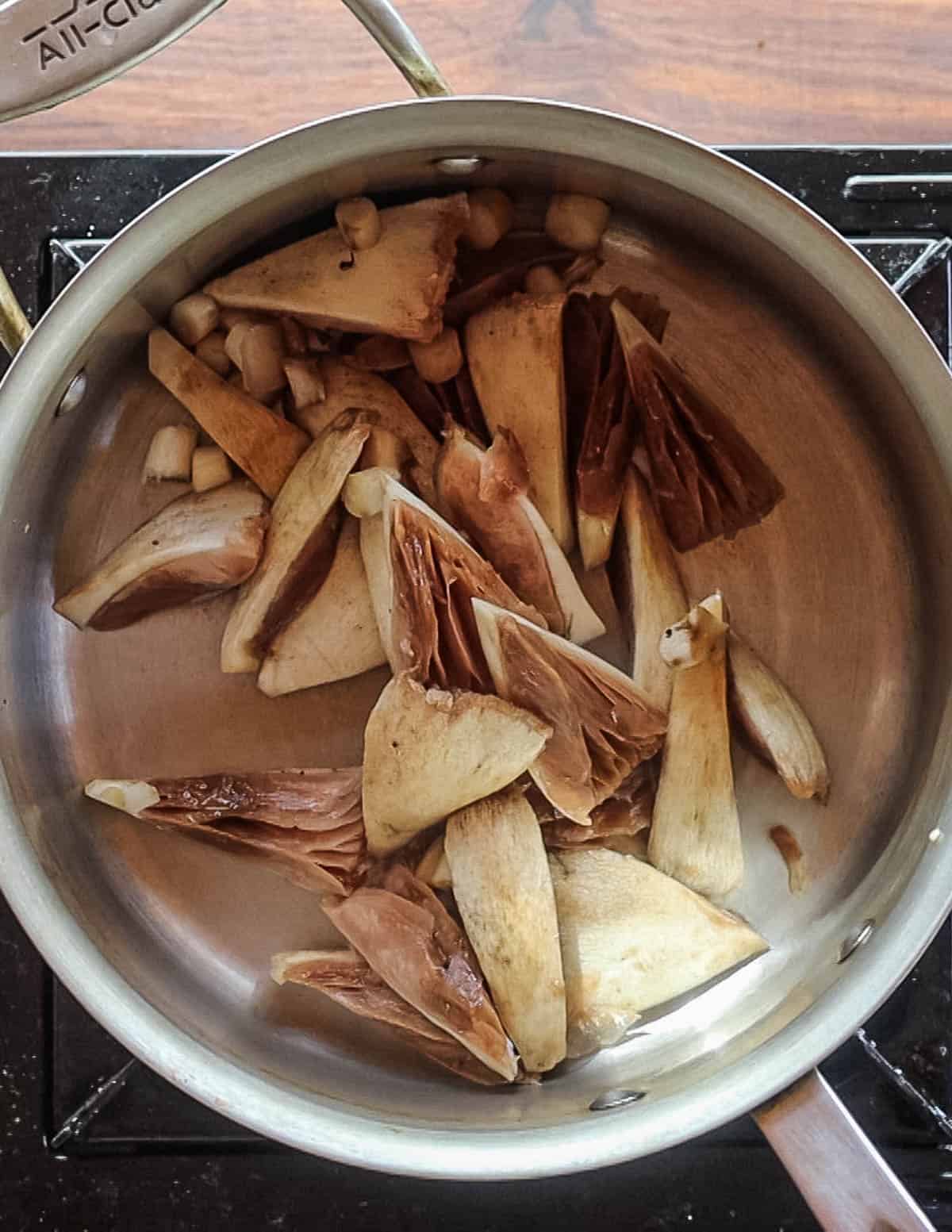 Cooking mushrooms for Thai soup in a pan. 