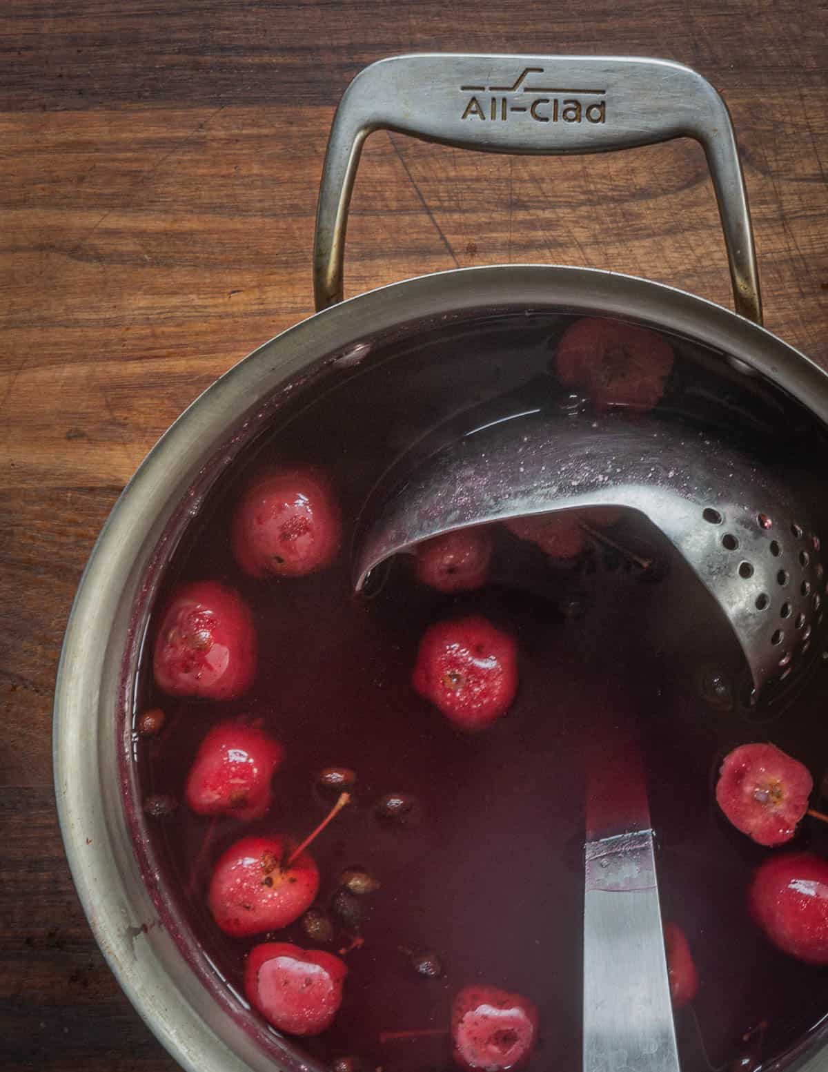 A pot of crab apple cider with a ladle. 