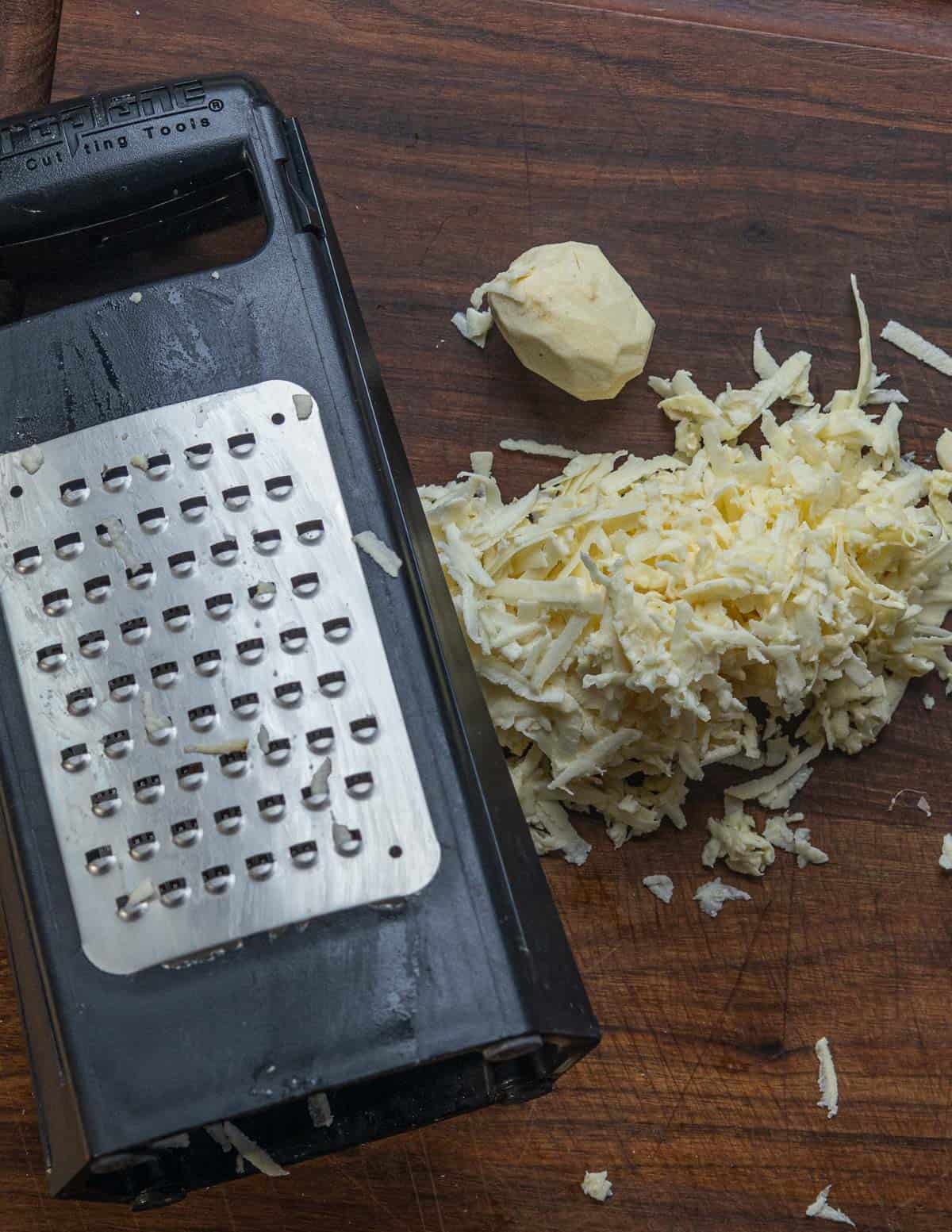 Grating katniss potatoes on a microplane grater.