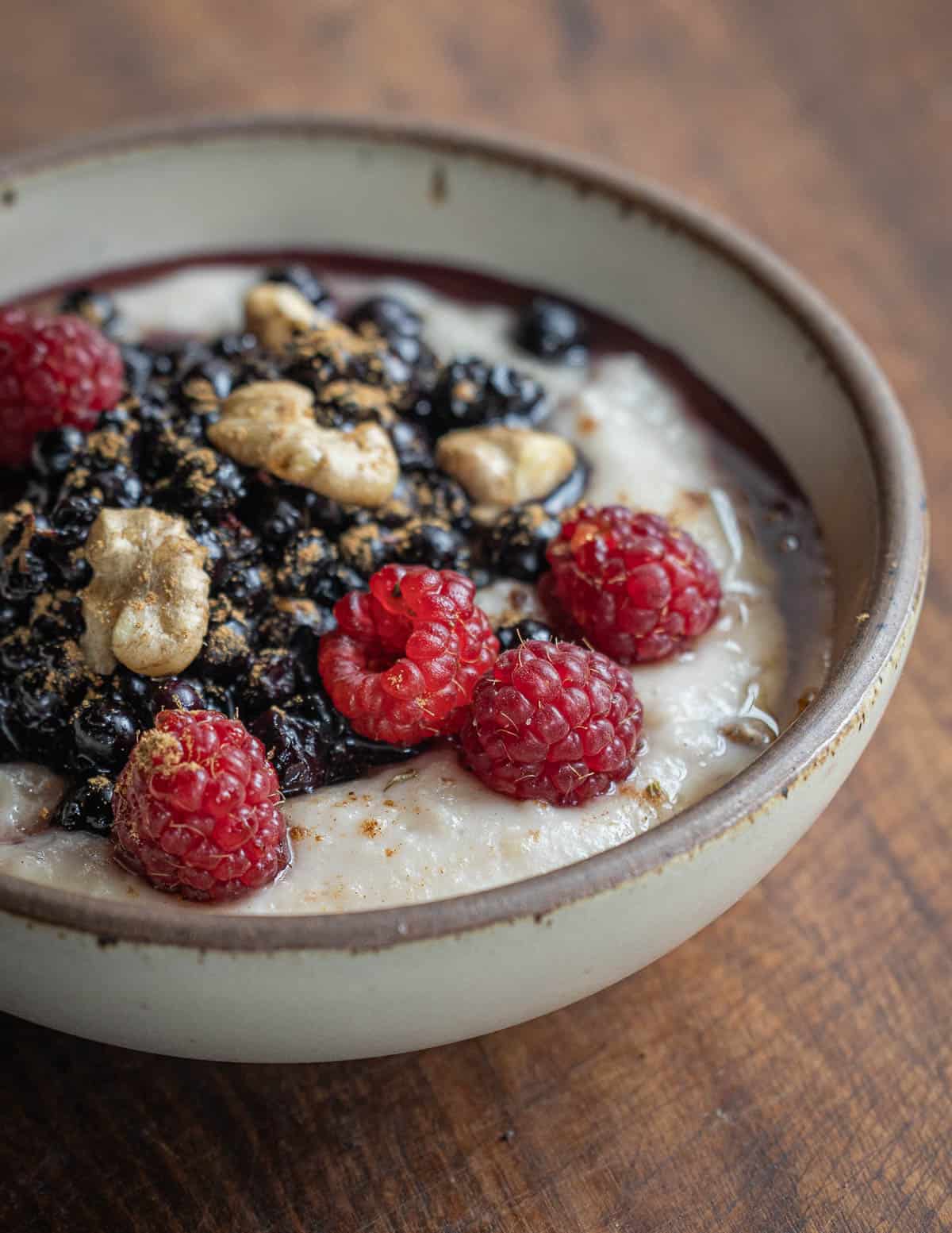 A bowl of wapato flour or katniss oatmeal with wild blueberries, raspberries, and black walnuts. 