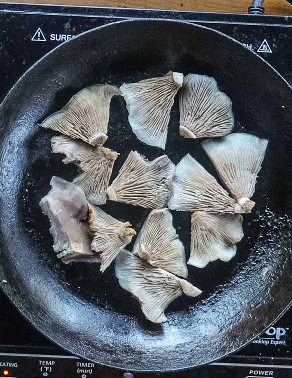 Wood blewit mushrooms cooking in a carbon steel pan. 