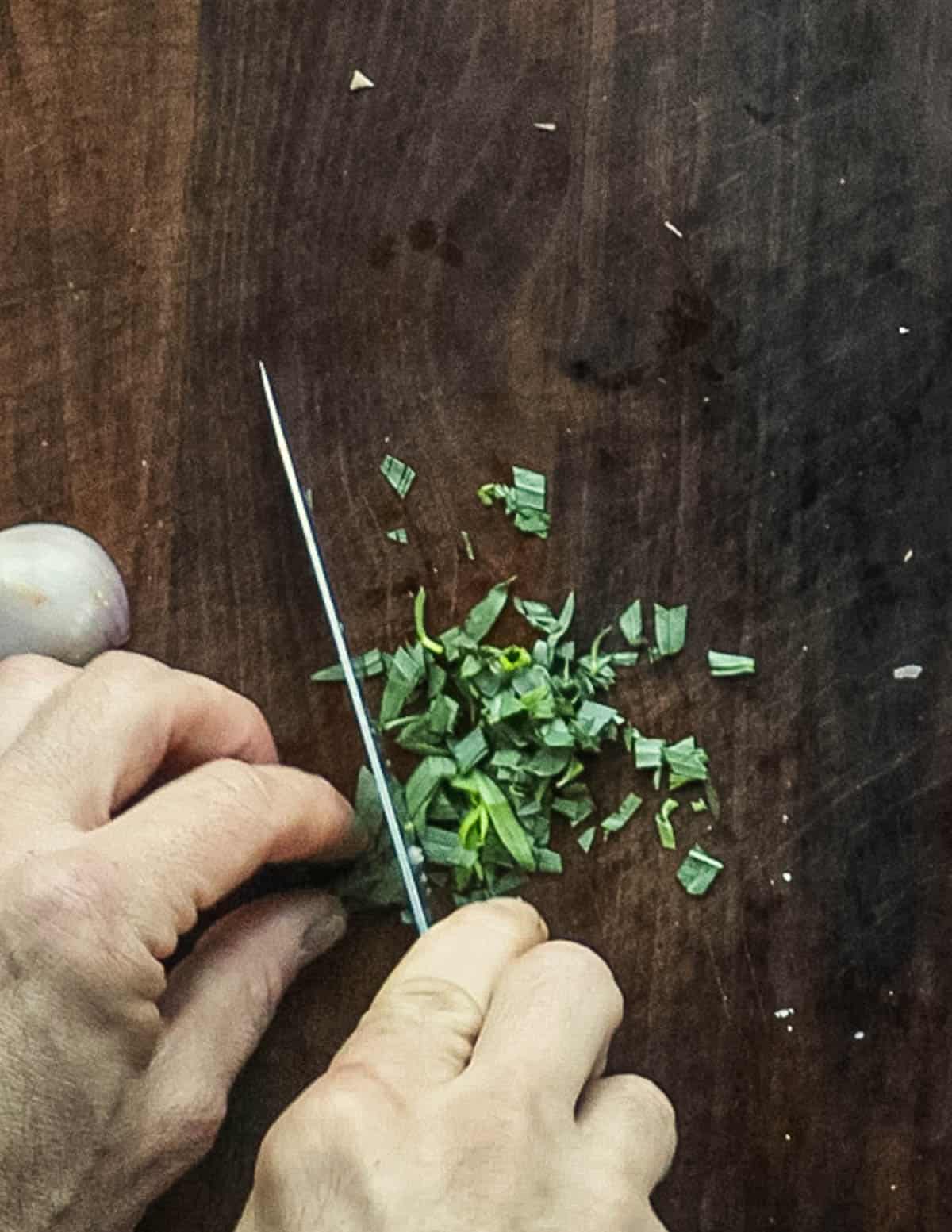 Roughly chopping fresh tarragon. 