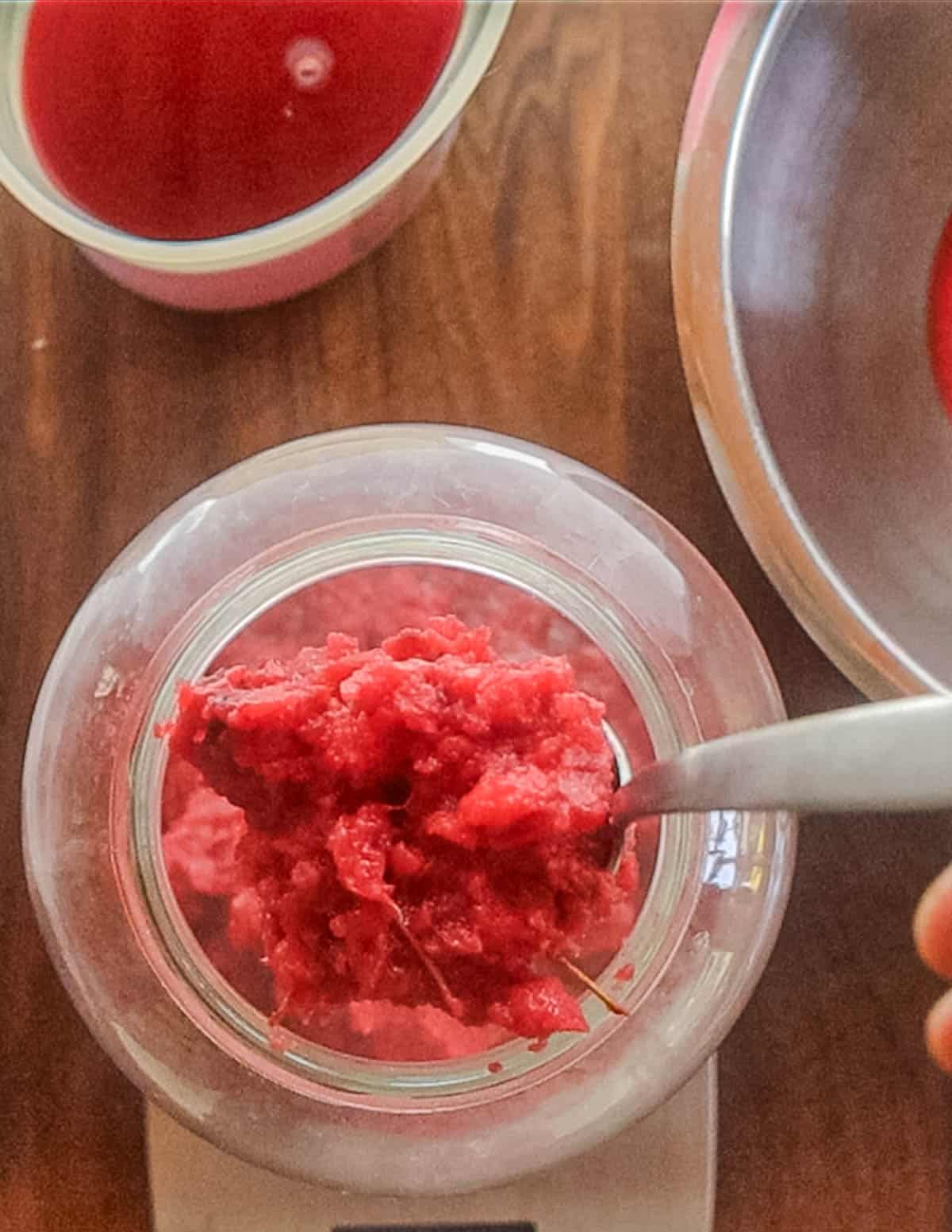 Adding fruit scrap to a jar. 