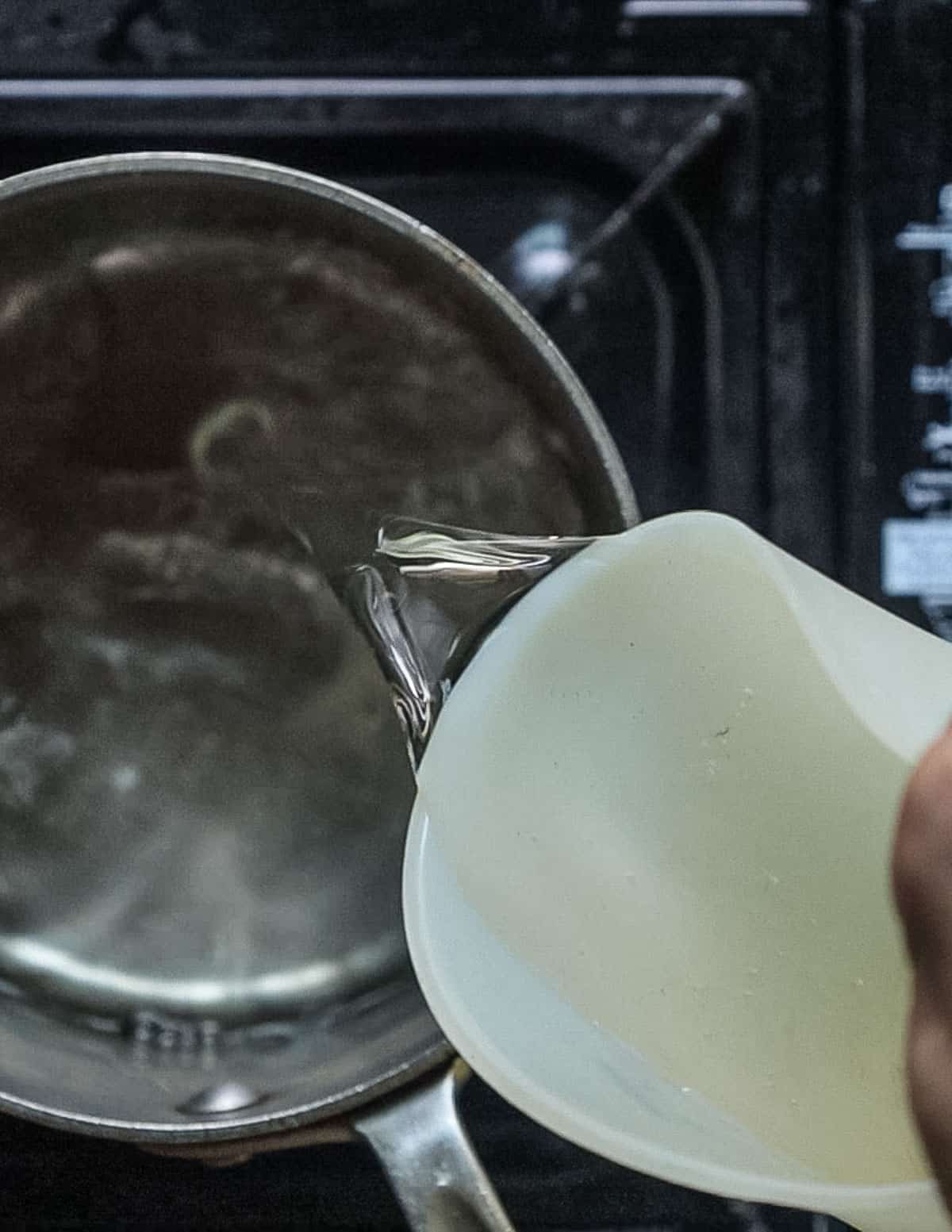 Pouring water into a pot to make homemade dashi. 