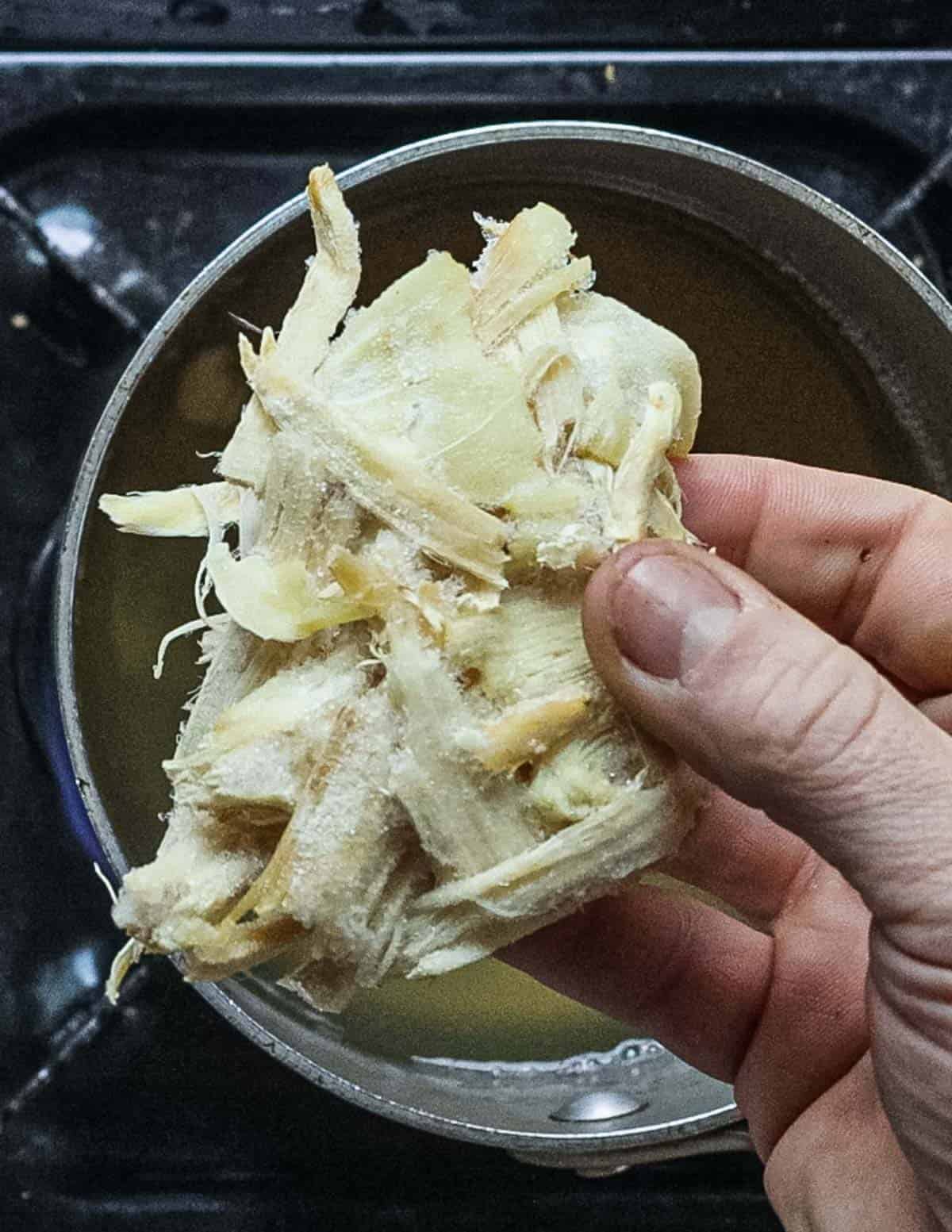 Adding frozen matsutake pine mushrooms to dashi stock. 