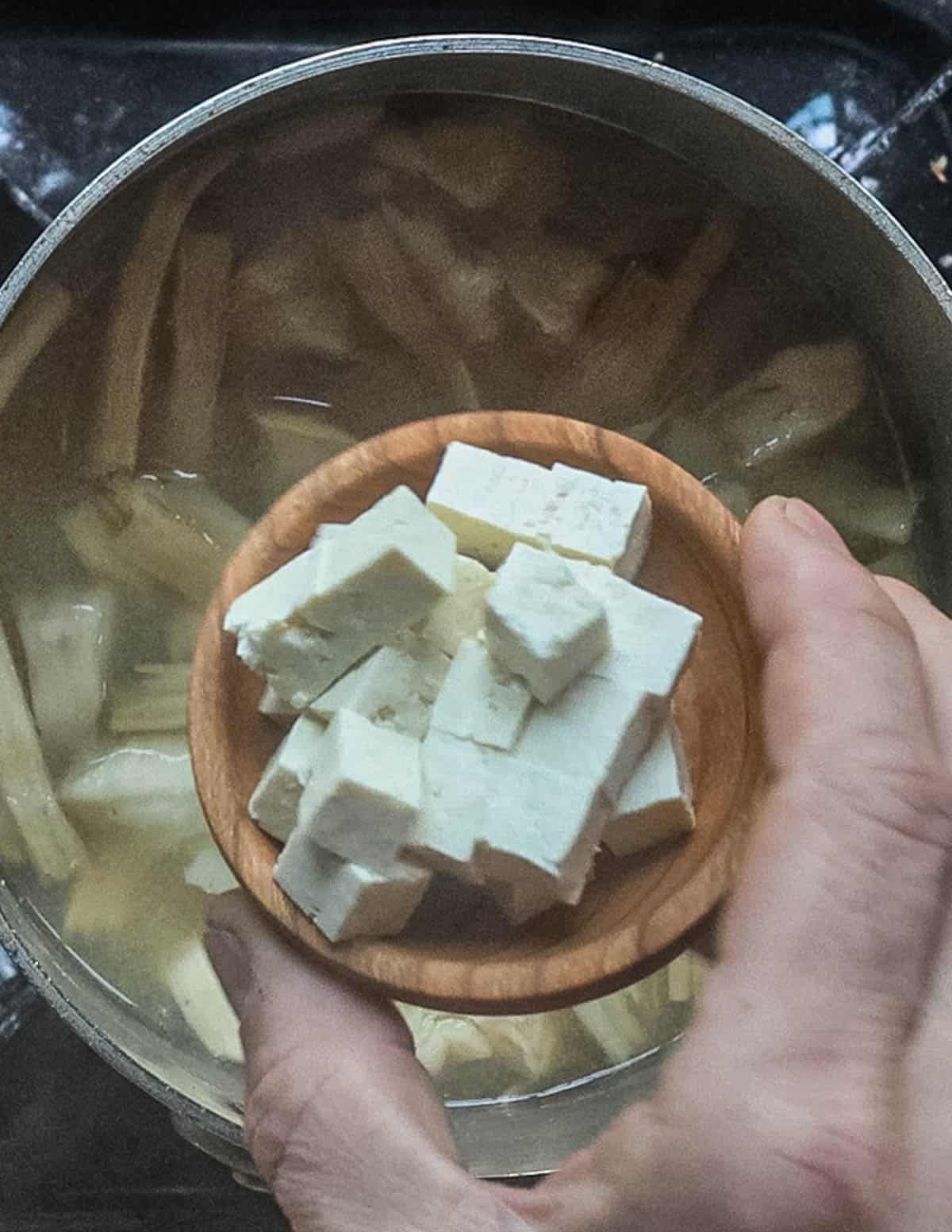 Adding tofu to a pot of miso soup.