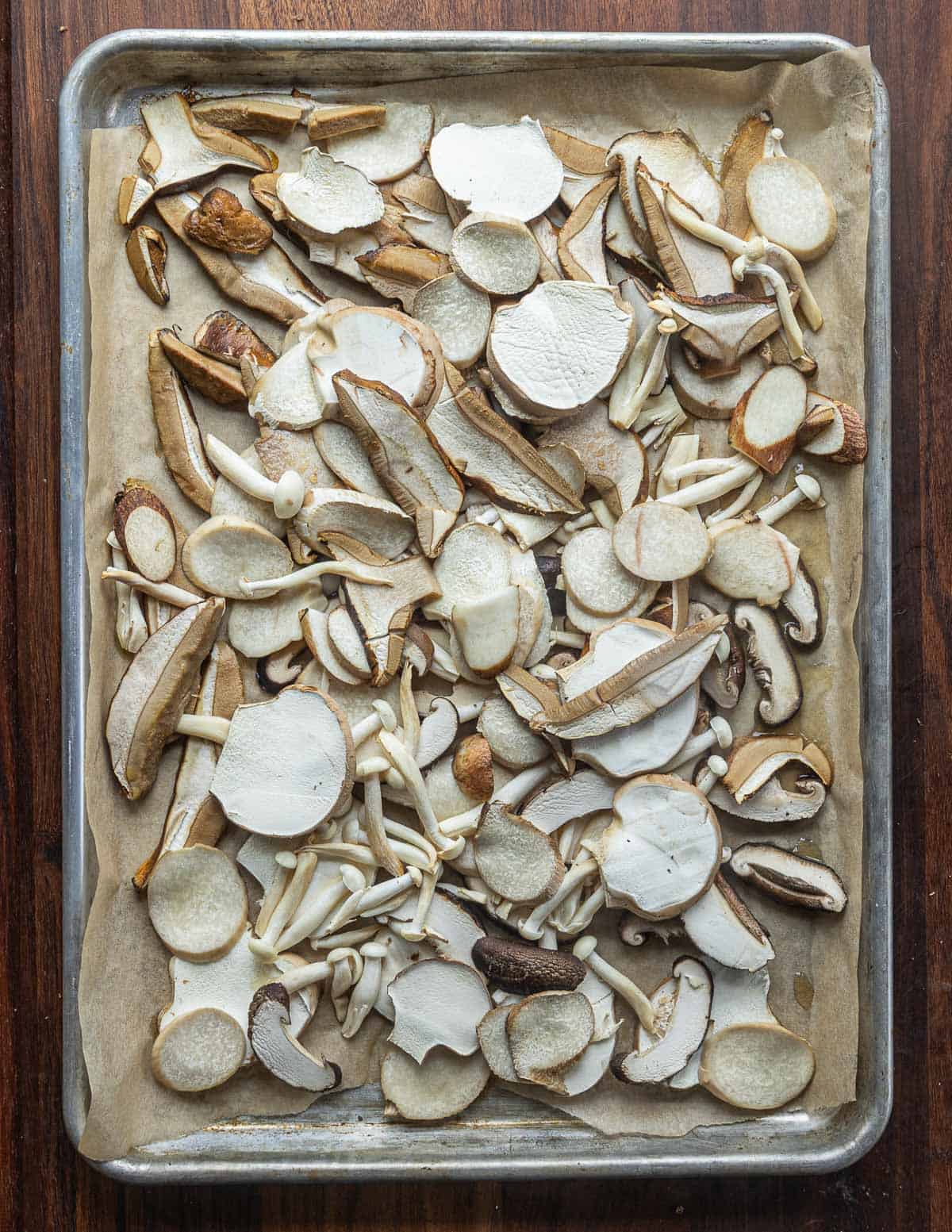 A baking sheet filled with cooked oyster, porcini and puffball mushrooms. 