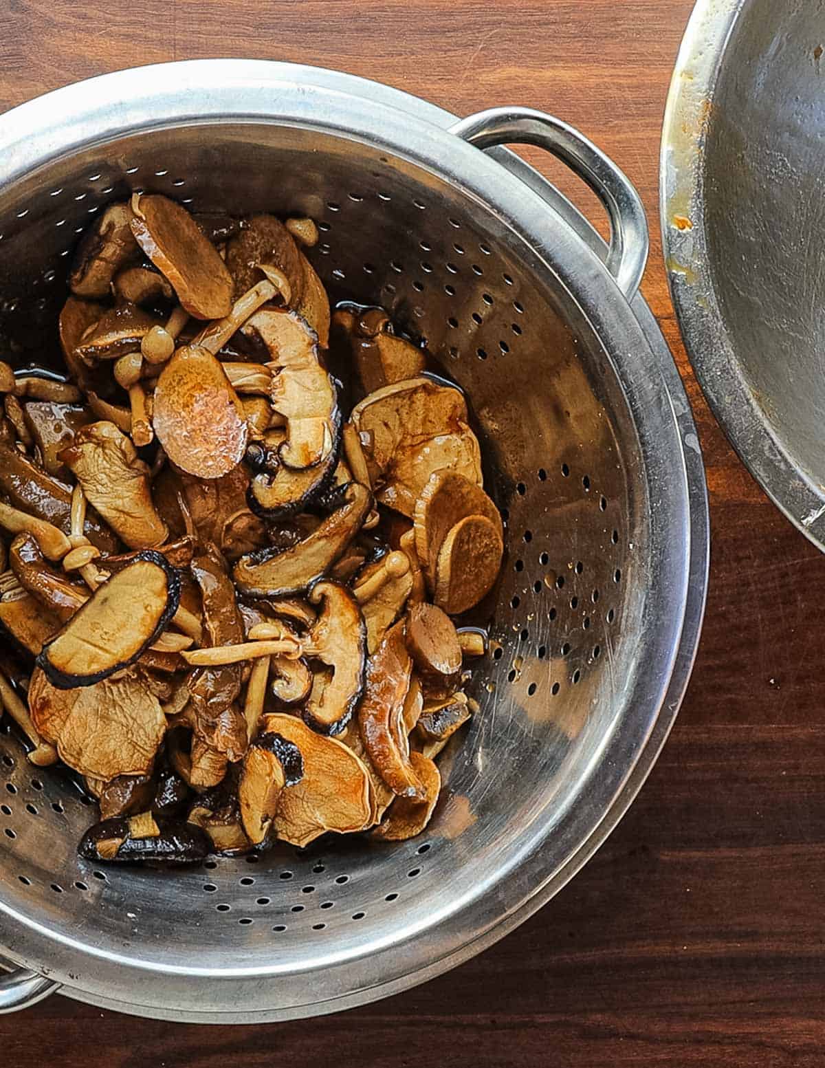 Draining marinated mushrooms in a colander. 