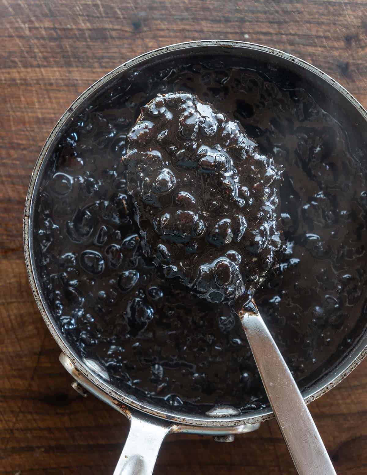 A spoonful of cooked nannyberries mashed up in a pot. 