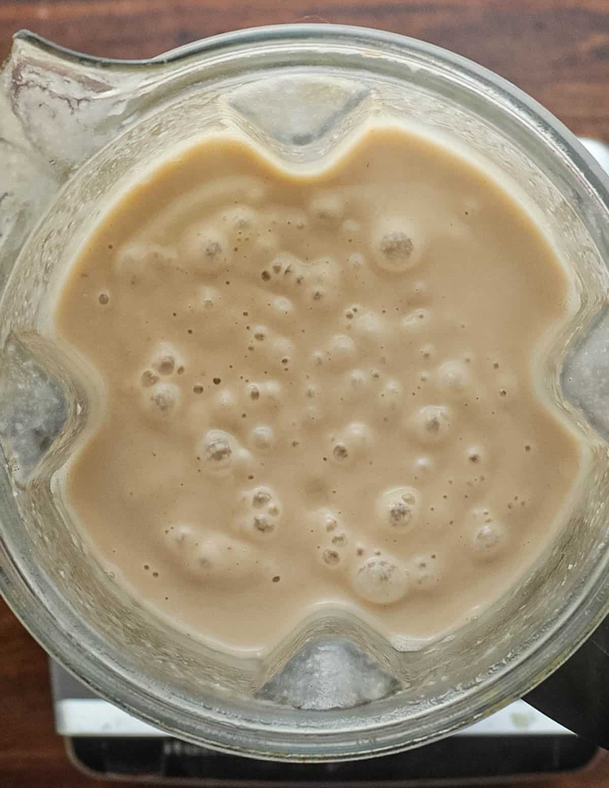 A top down image of a blender filled with pureed chestnut soup.