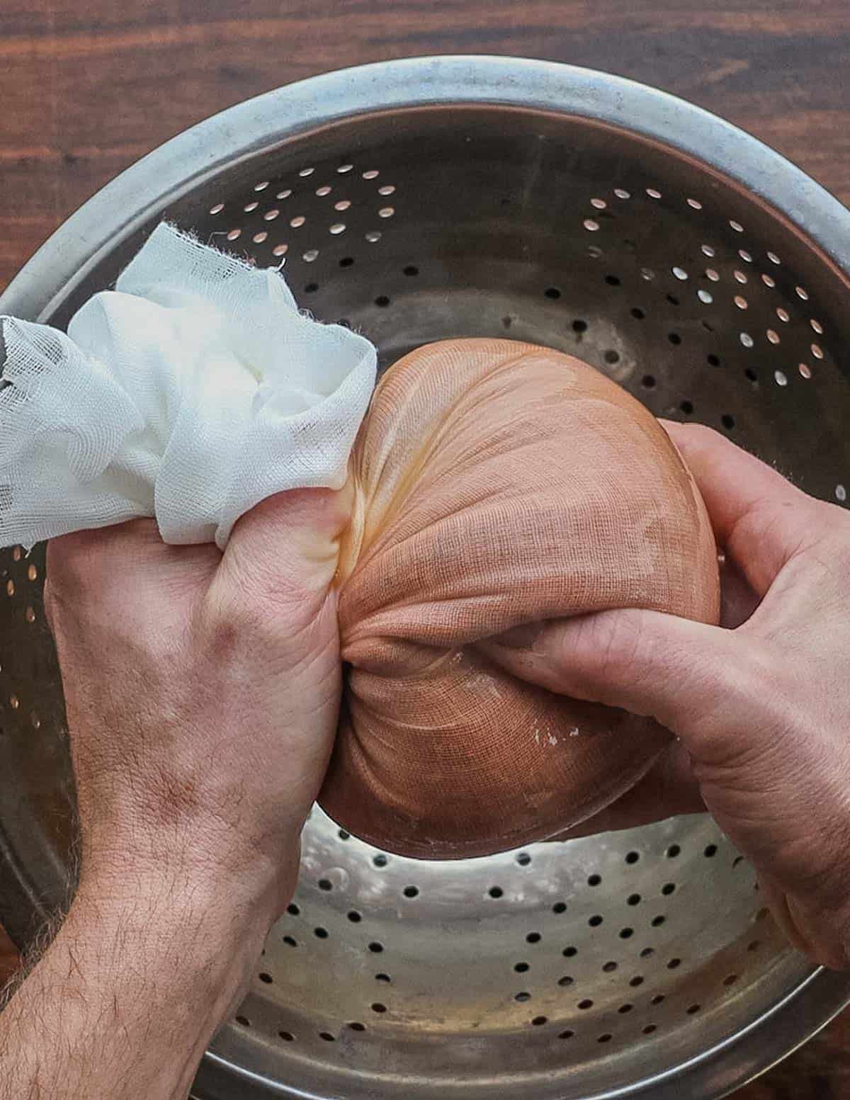 Squeezing rosehip liquid through cheesecloth. 
