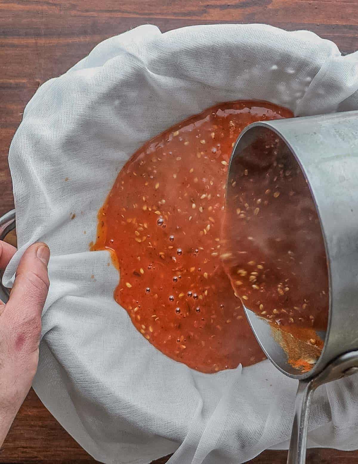 Straining rose hip liquid through cheesecloth. 