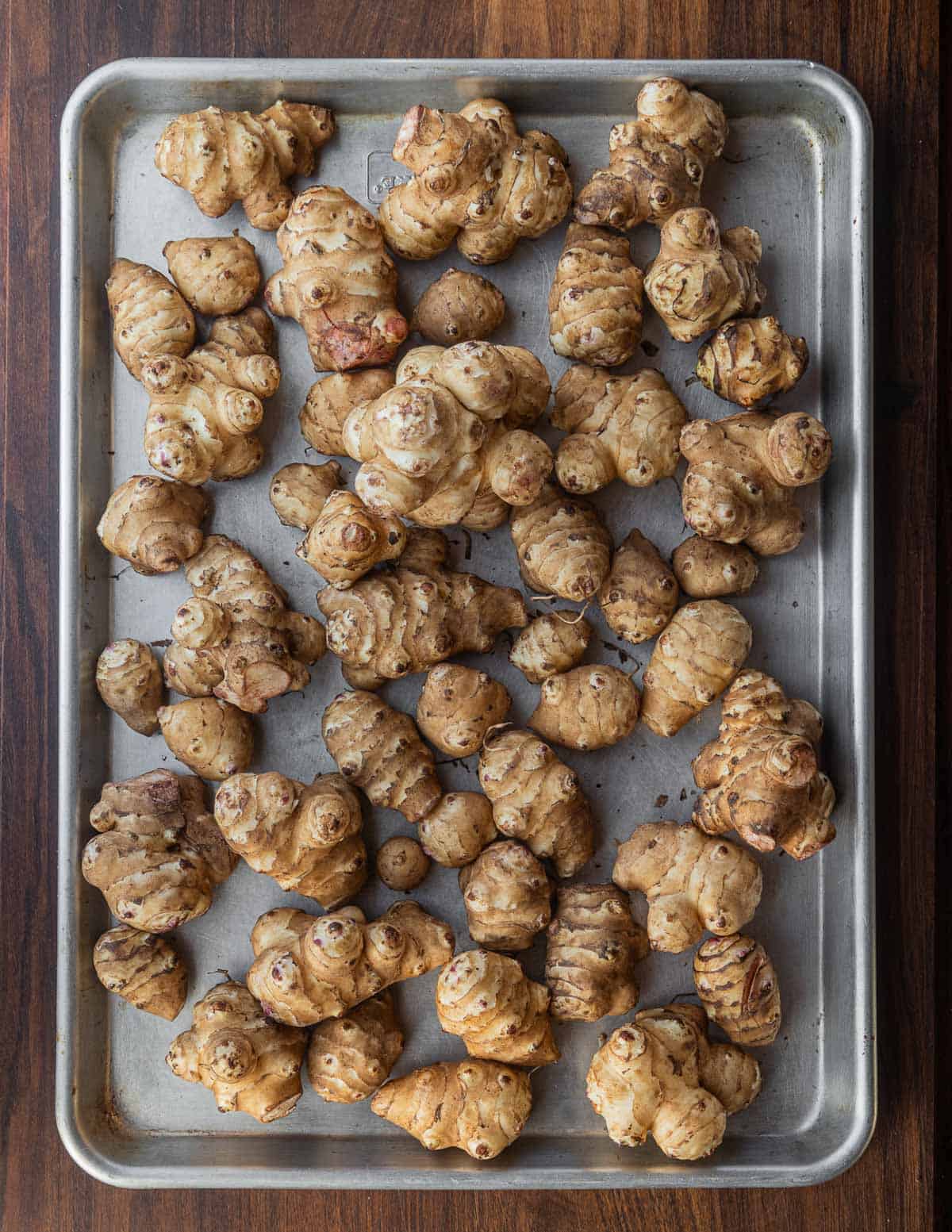 A baking sheet filled with cultivated sunchokes. 