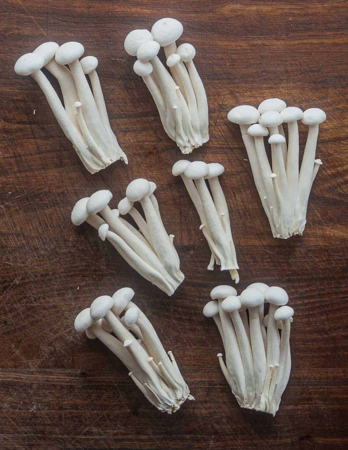 Clusters of white beech mushrooms on a cutting board. 