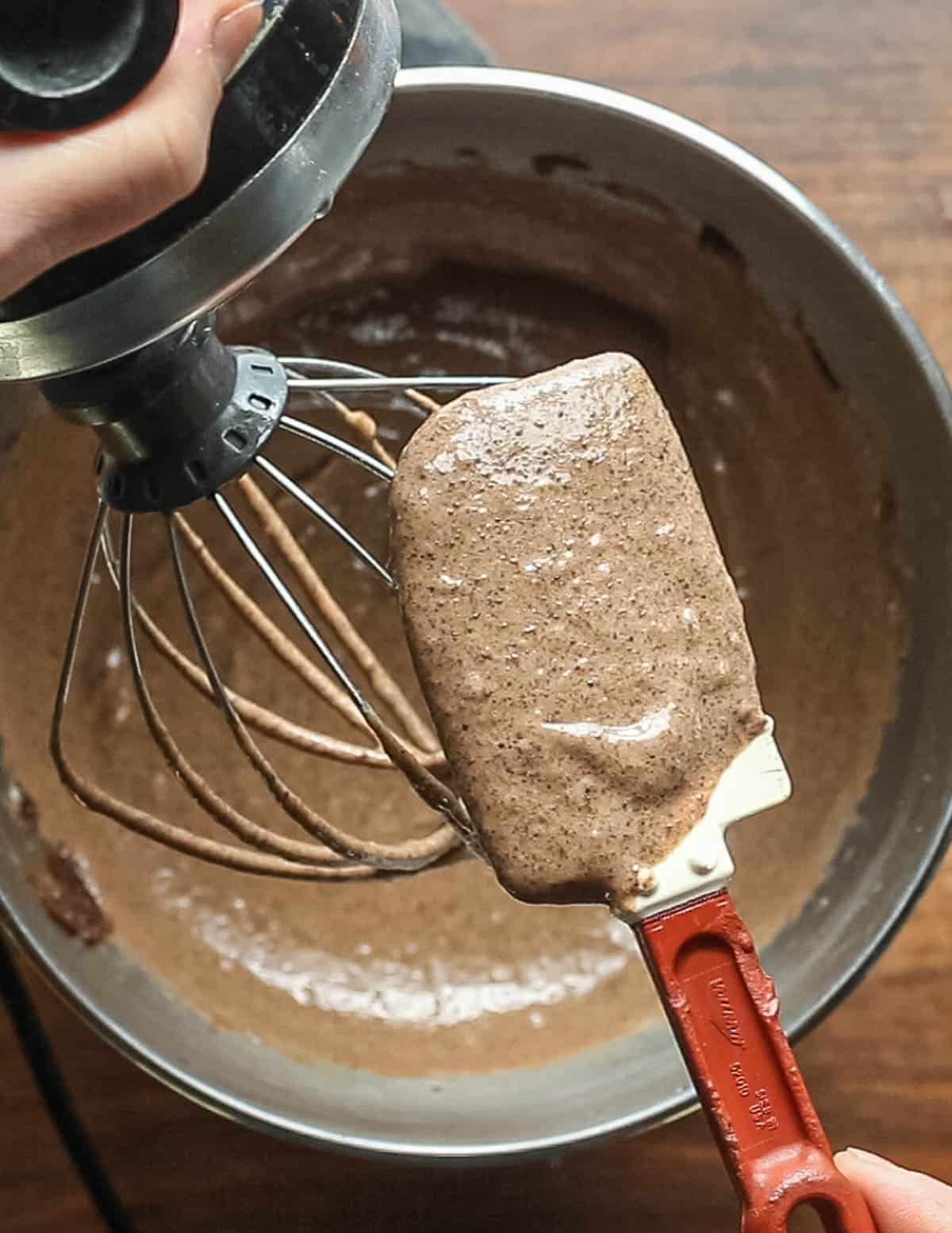 A spatula showing the light, fluffy color of a brown cake batter. 
