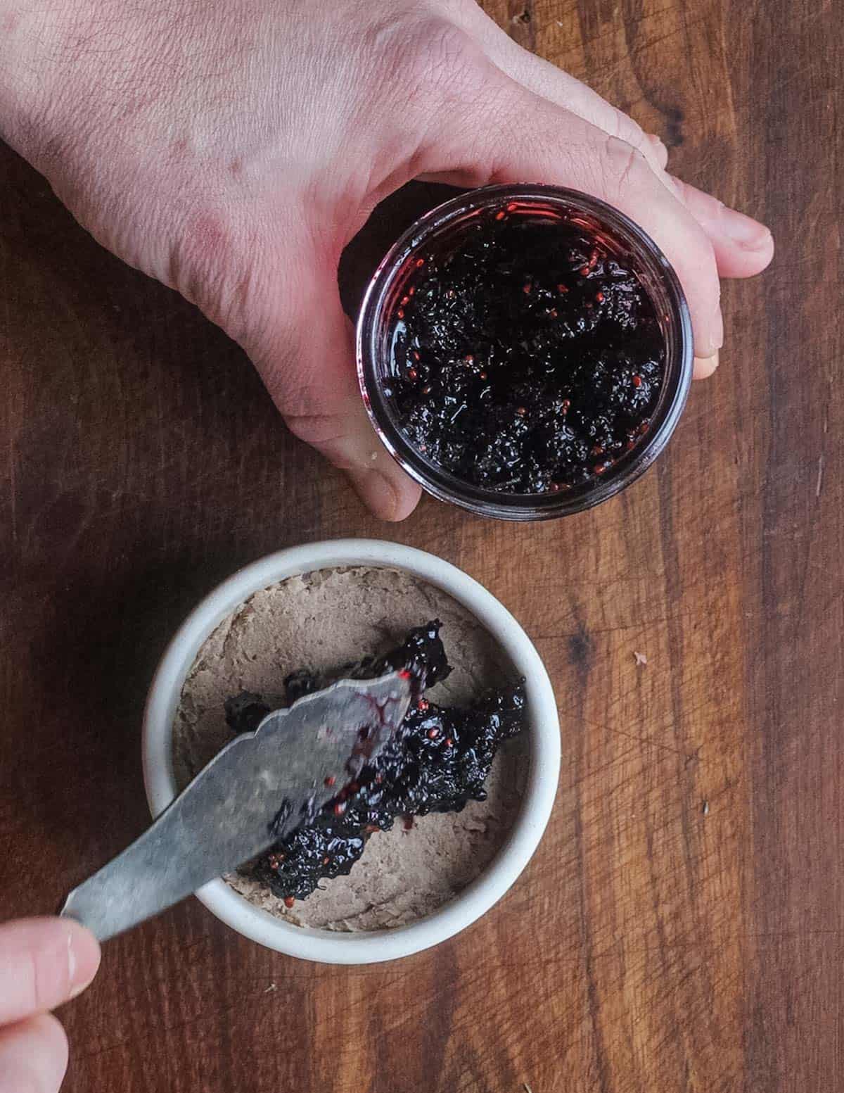 Topping a crock of rillettes with mulberry preserves before serving. 