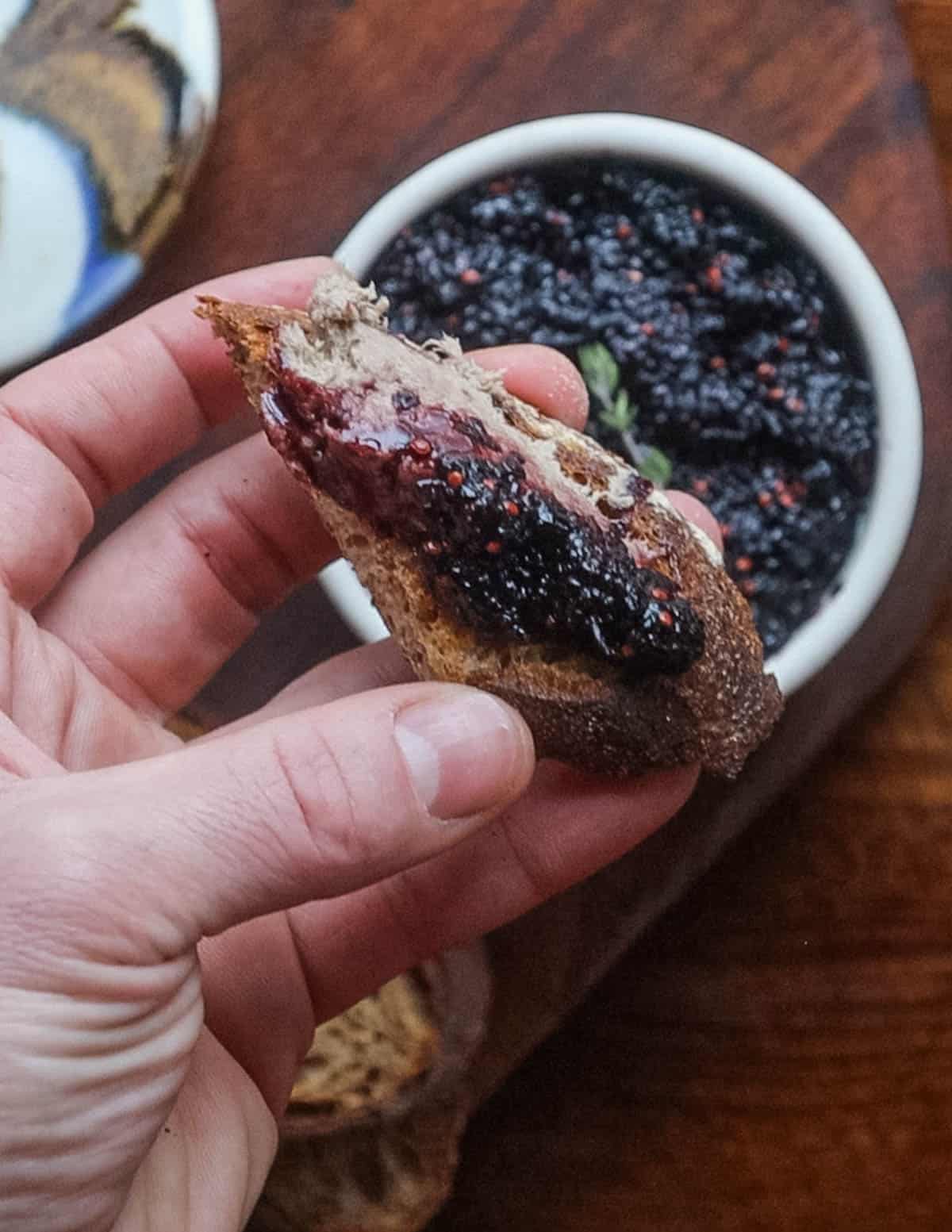 A piece of sourdough bread with rillettes and jam on top. 