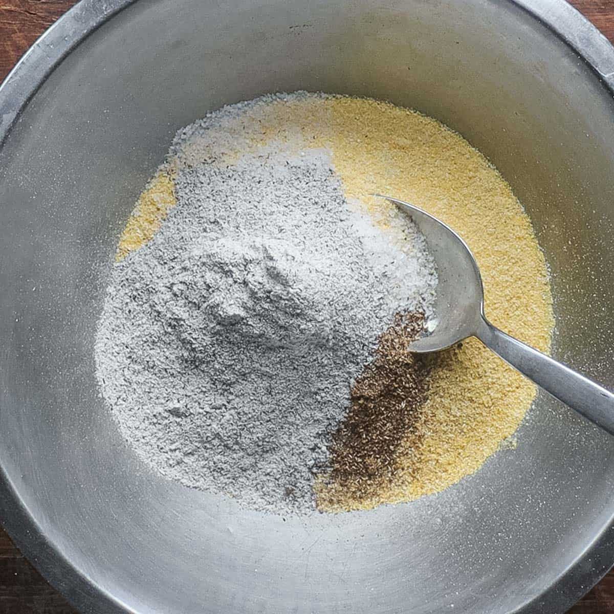 Mixing cornmeal, buckwheat flour and spices together. 