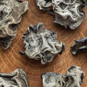 A close up image of dried wood ear mushrooms (Auricularia heimuer) on a cutting board.