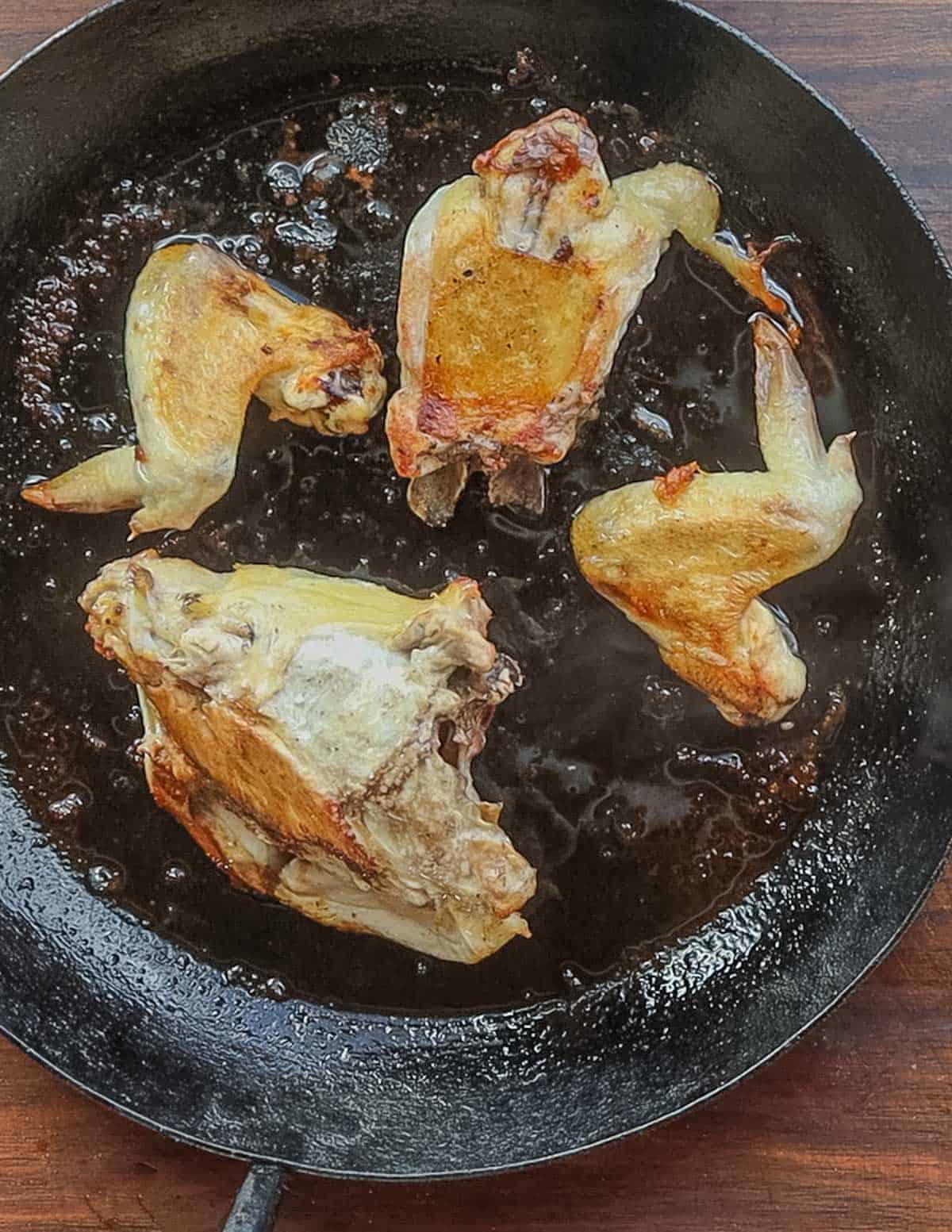 A pan full of roasted chicken bones and wings. 