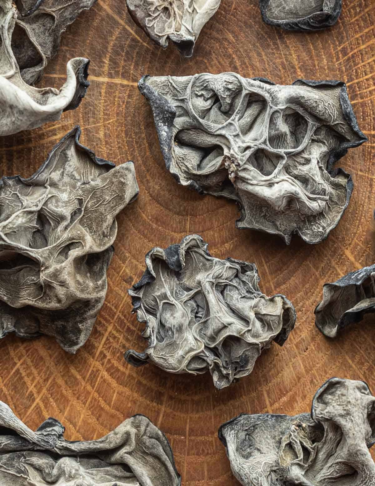 A close up image of dried wood ear mushrooms (Auricularia heimuer) on a cutting board. 
