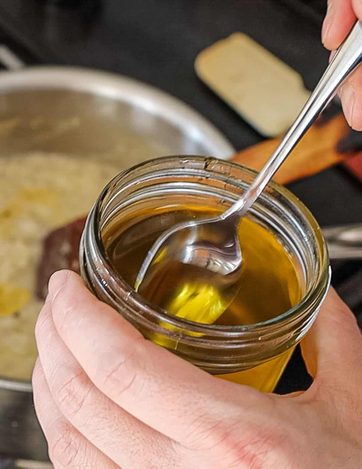 Adding a spoonful of truffle oil to a pot of risotto. 
