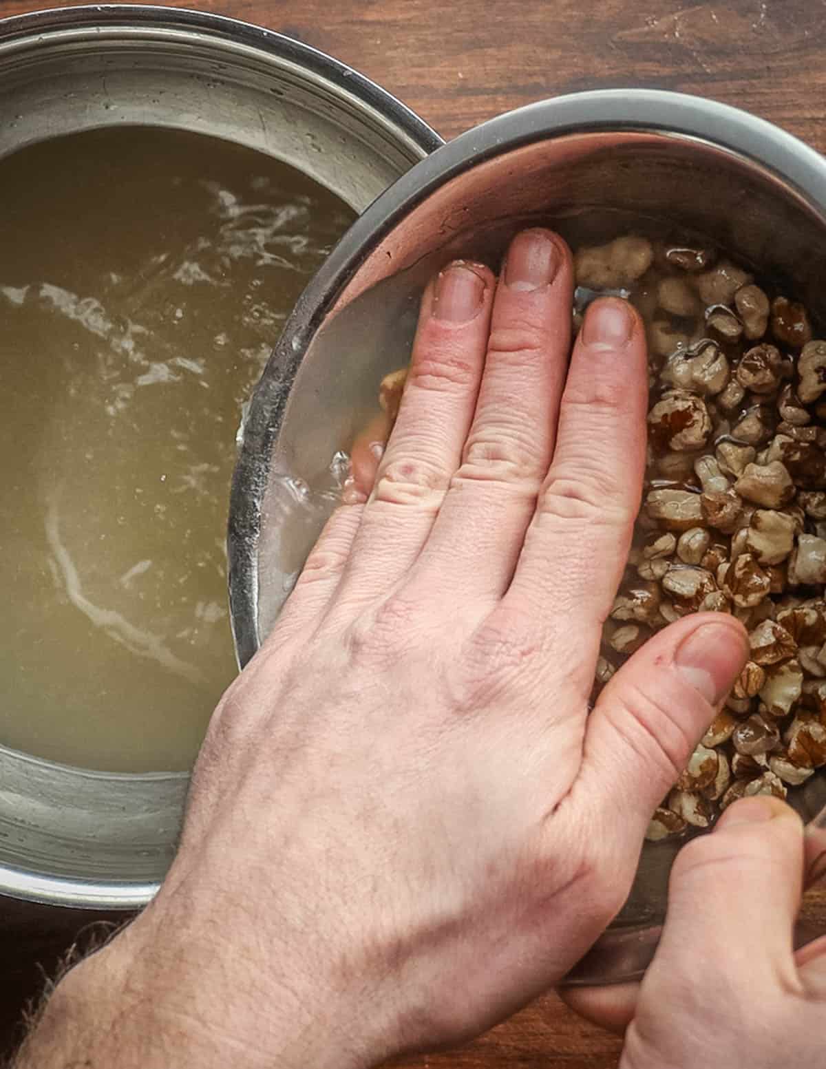 Straining the water from black walnuts before making homemade nut milk. 