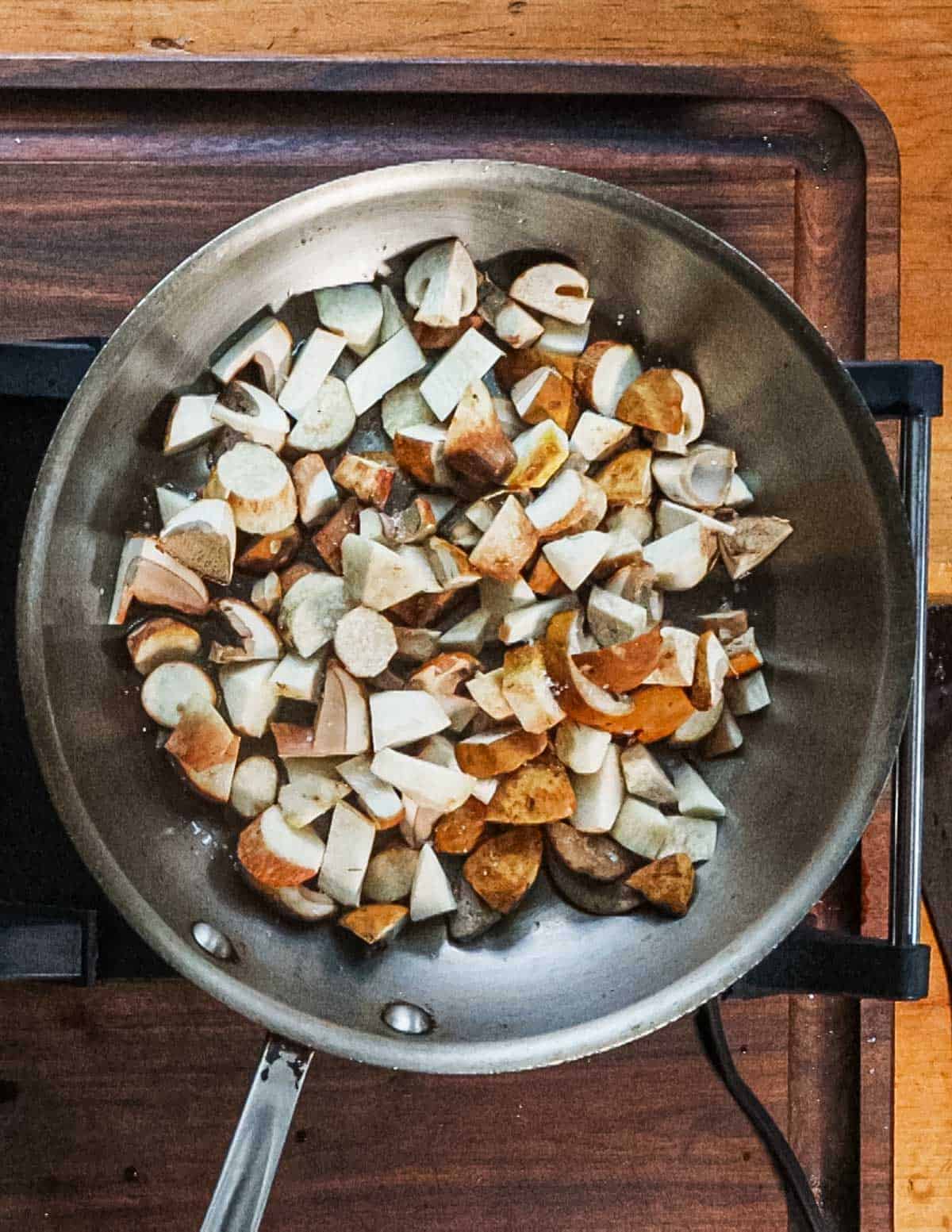 Cooking fresh bolete mushrooms in a saute pan. 