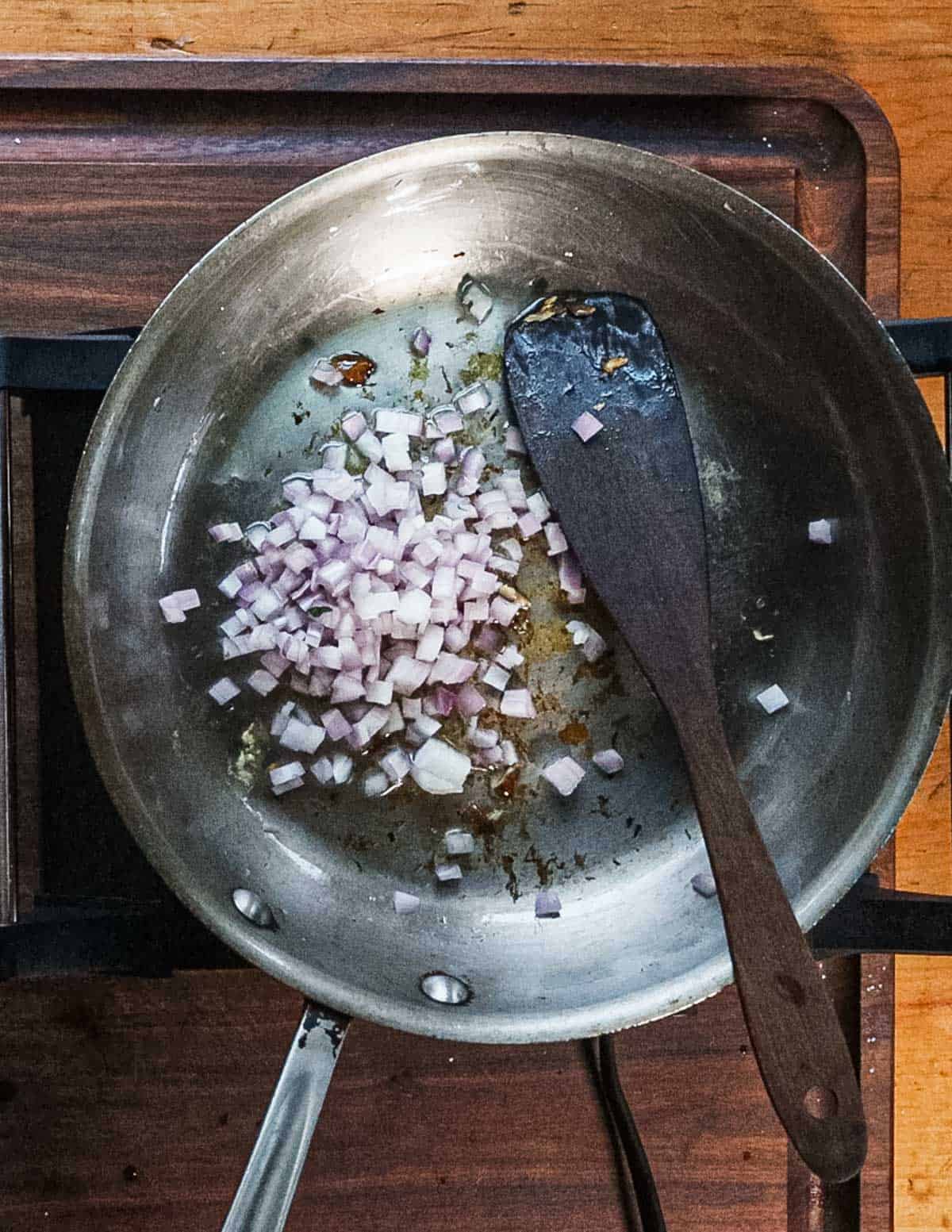 Cooking shallot and garlic in a saute pan. 
