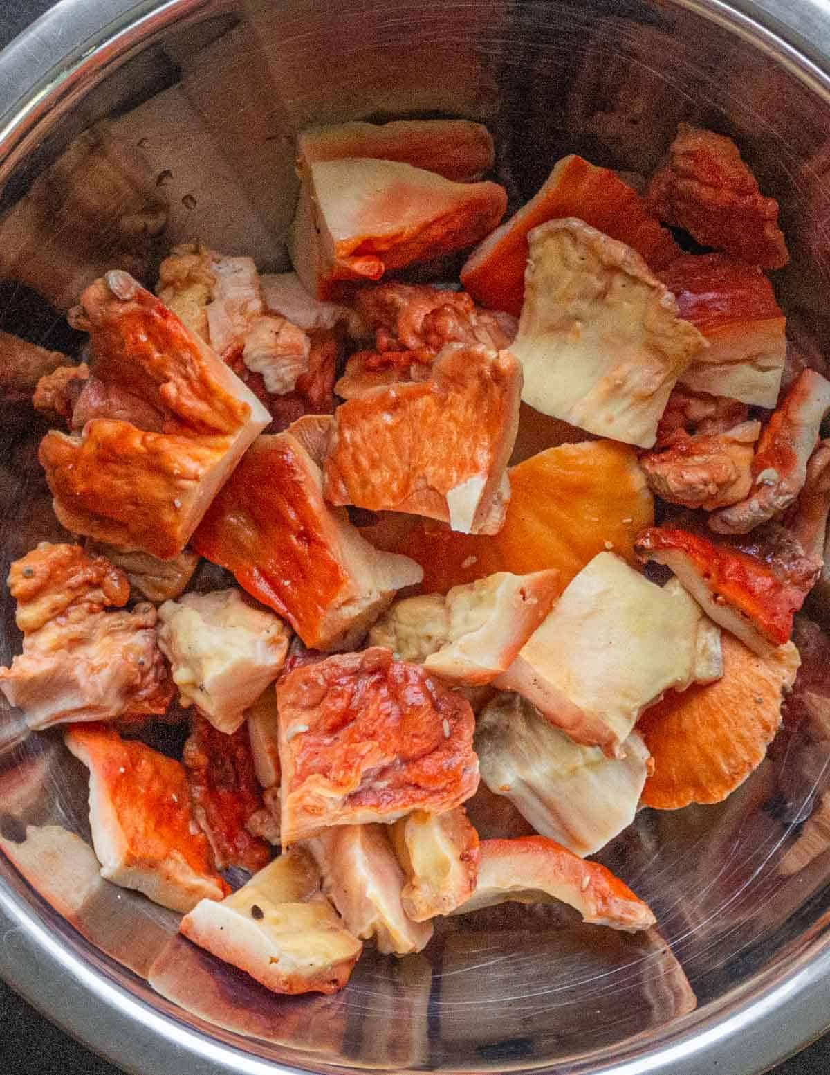 A bowl of cooked orange mushrooms cut into large pieces. 
