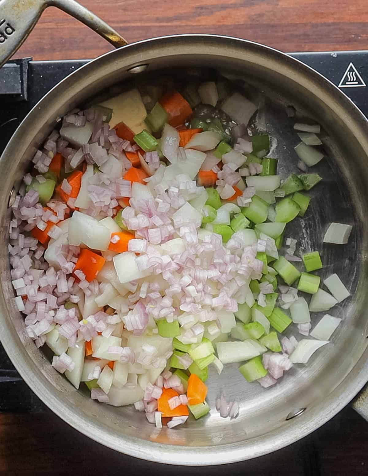 Cooking carrot, onion and celery in a soup pot in butter. 