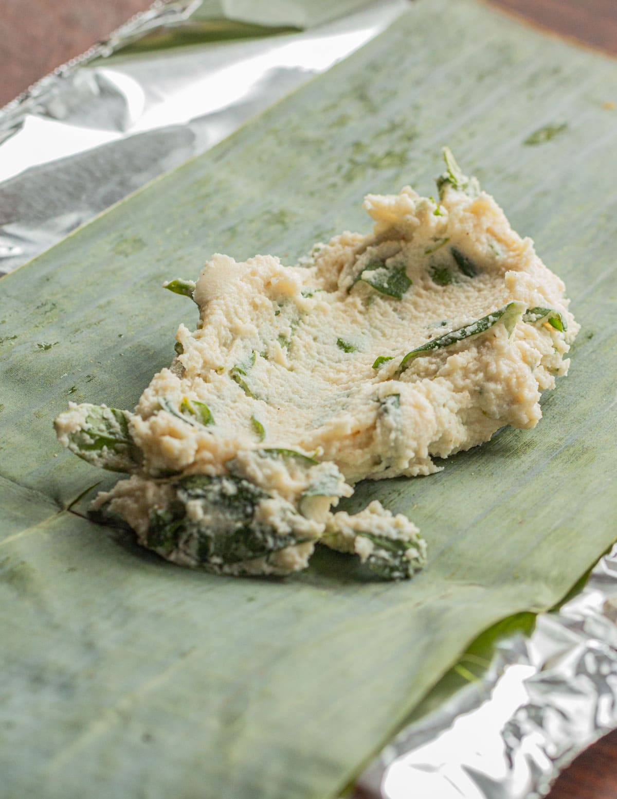 A spoonful of chipilin masa on a banana leaf. 