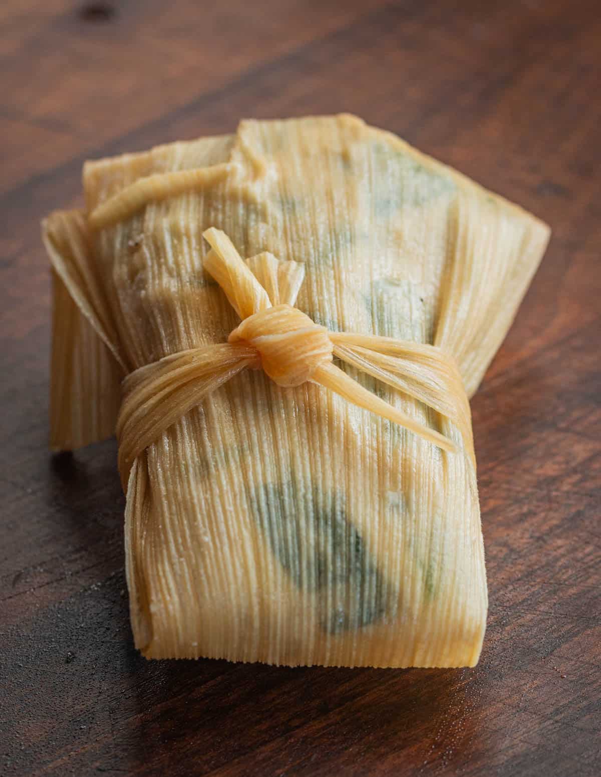 A chipilin tamal wrapped in a corn husk. 