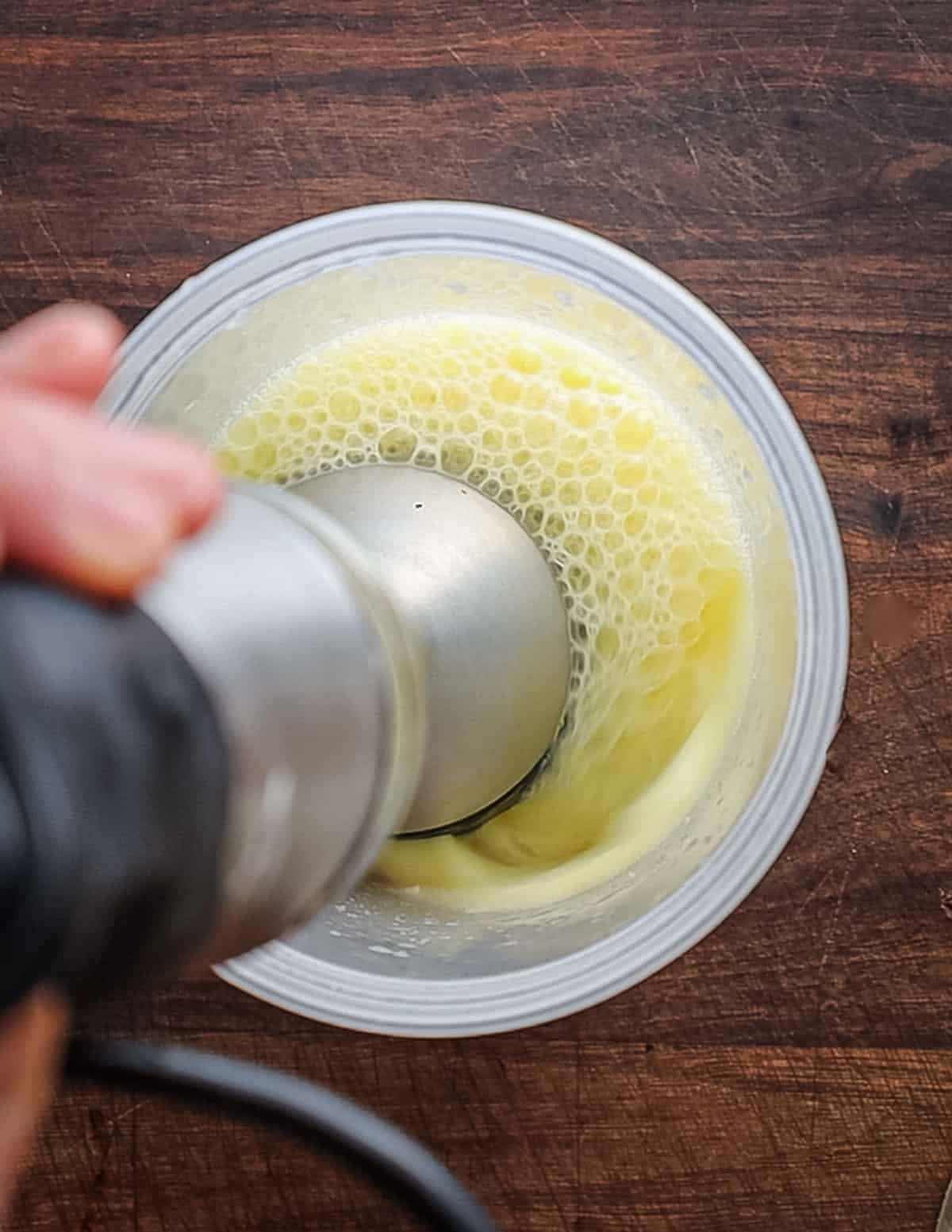 Pureeing an egg with garlic and lemon juice to make aioli. 