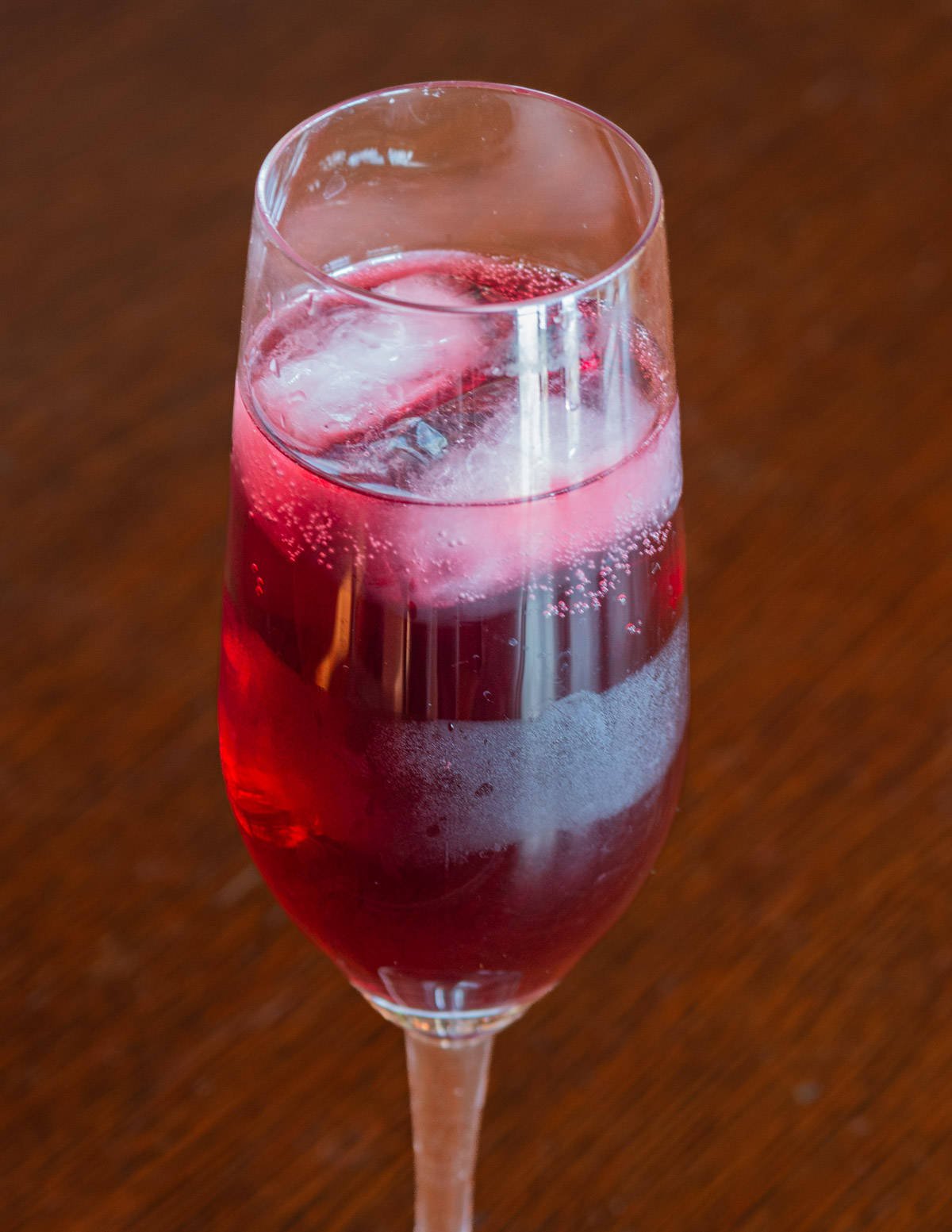 A close up image of a kir royale drink in a champagne flute. 