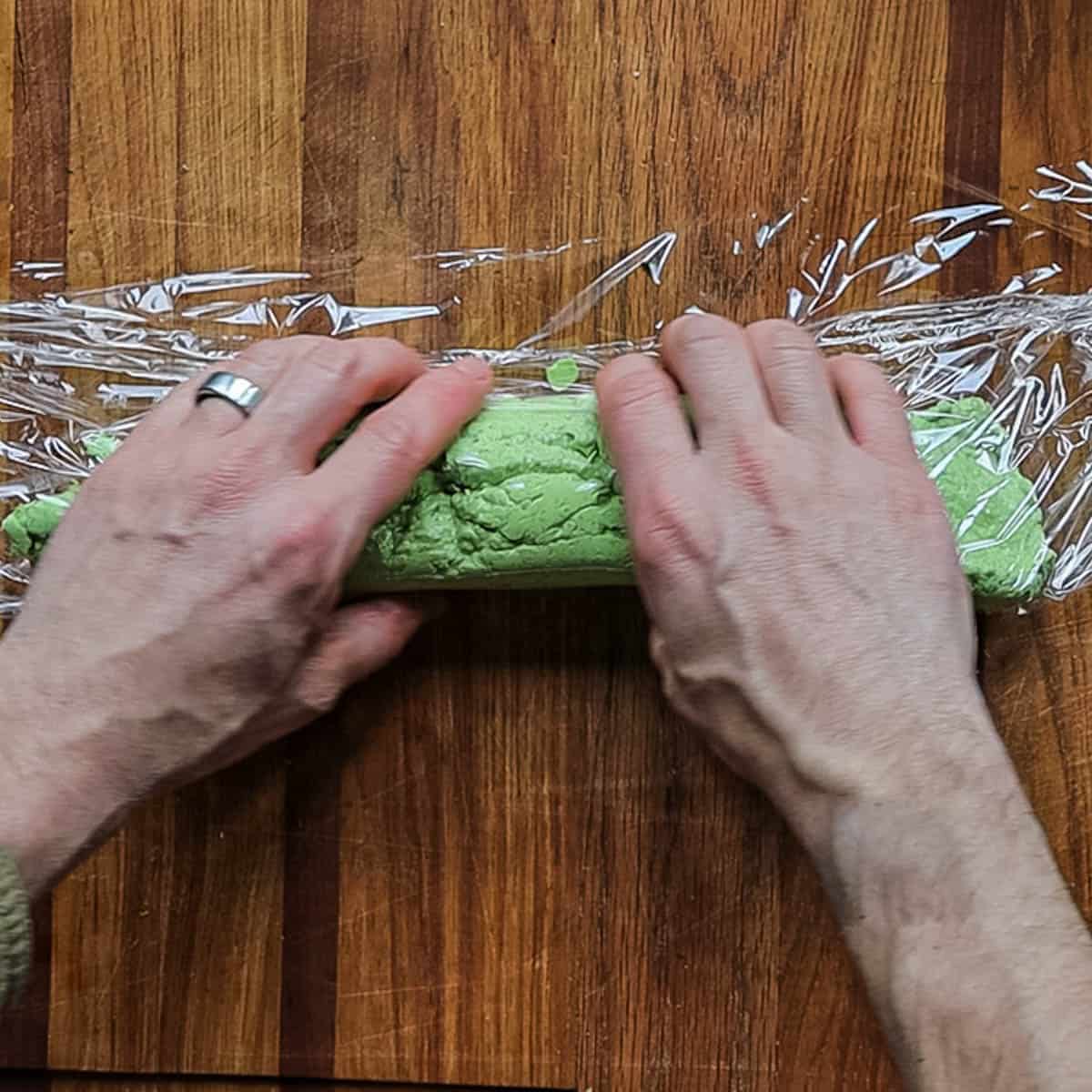 Rolling green ramp compound butter into a log form. 