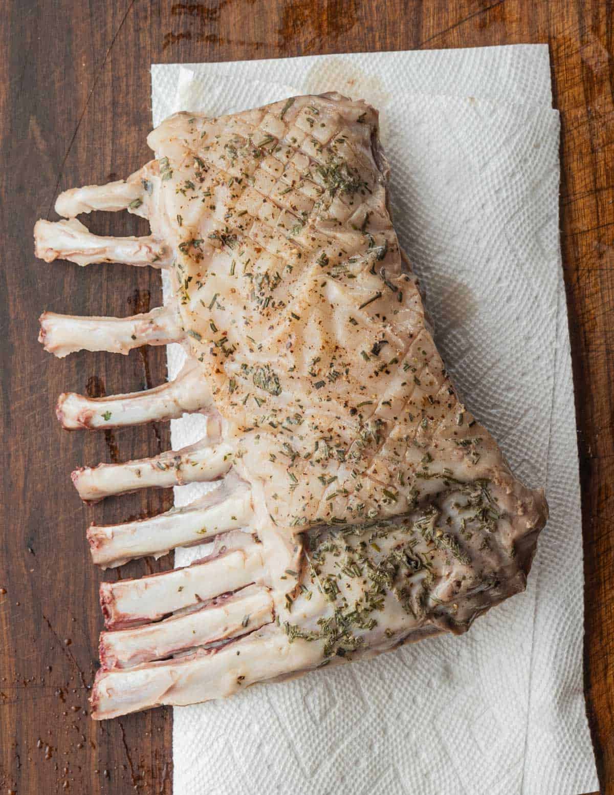 A whole rack of lamb cooked sous vide draining on a paper towel. 