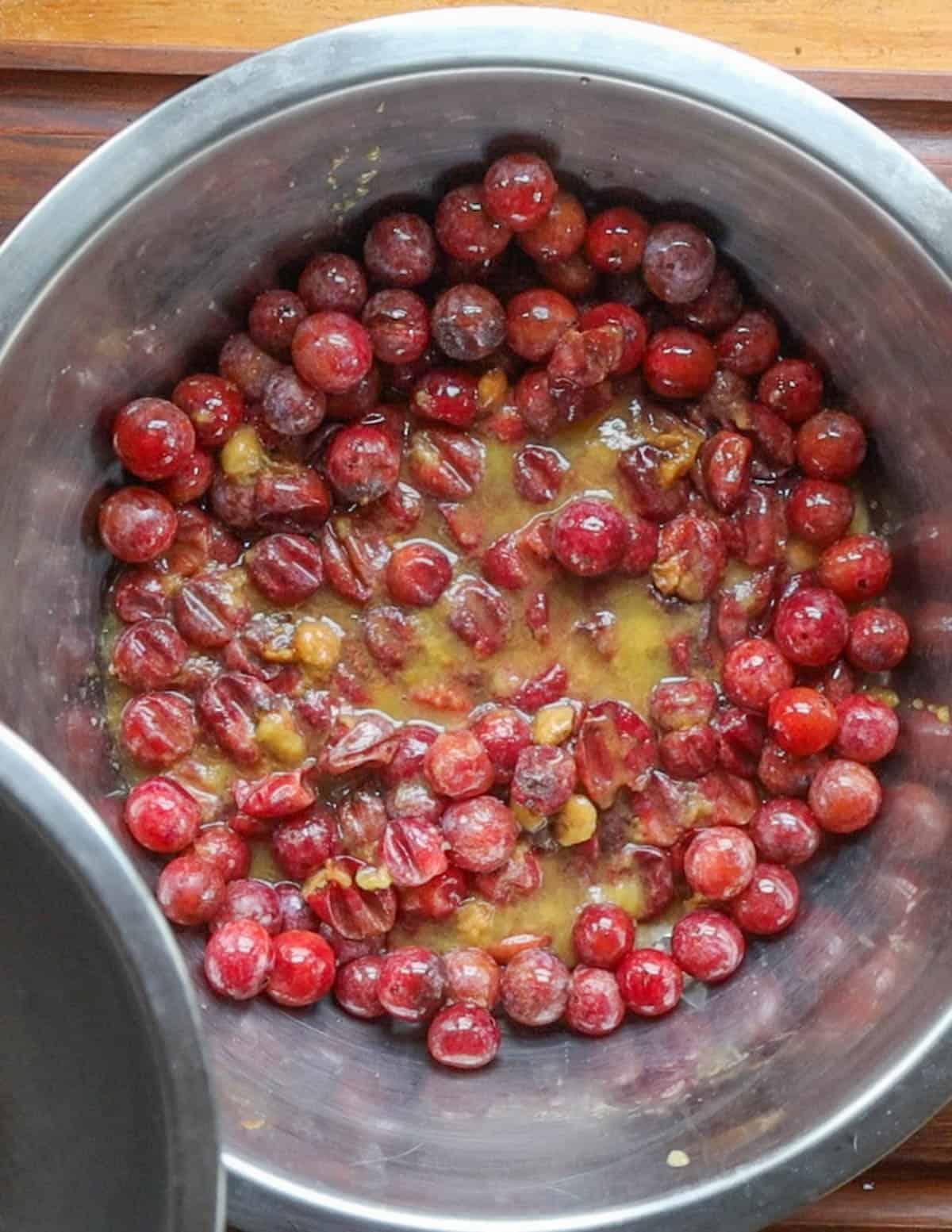 Crushing wild plums in a large bowl. 
