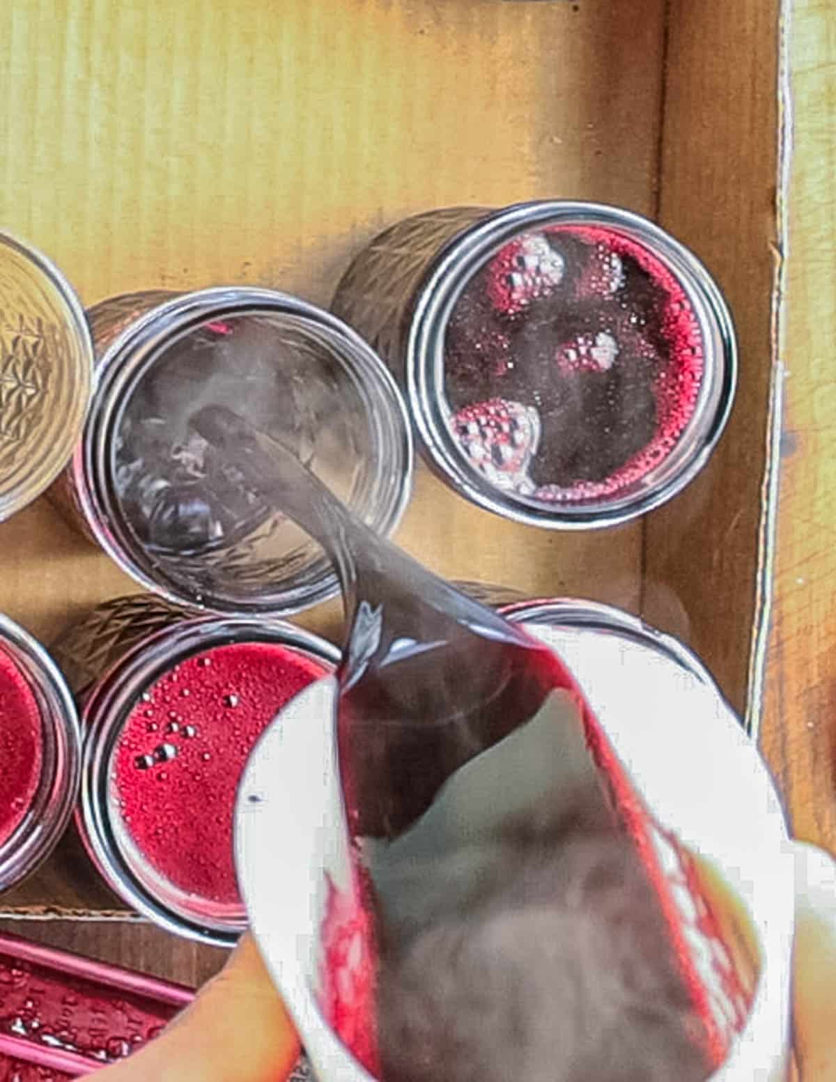 Pouring hot grape jelly into canning jars. 