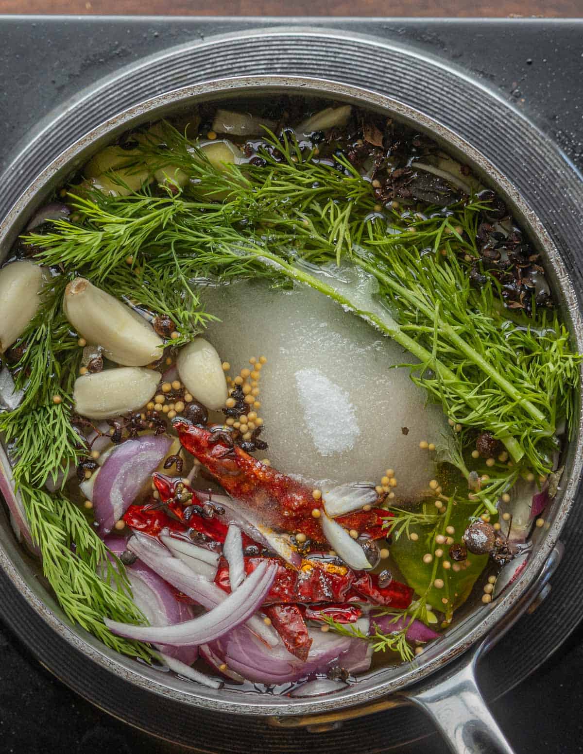 A close up image of a pot of pickle liquid cooking. 