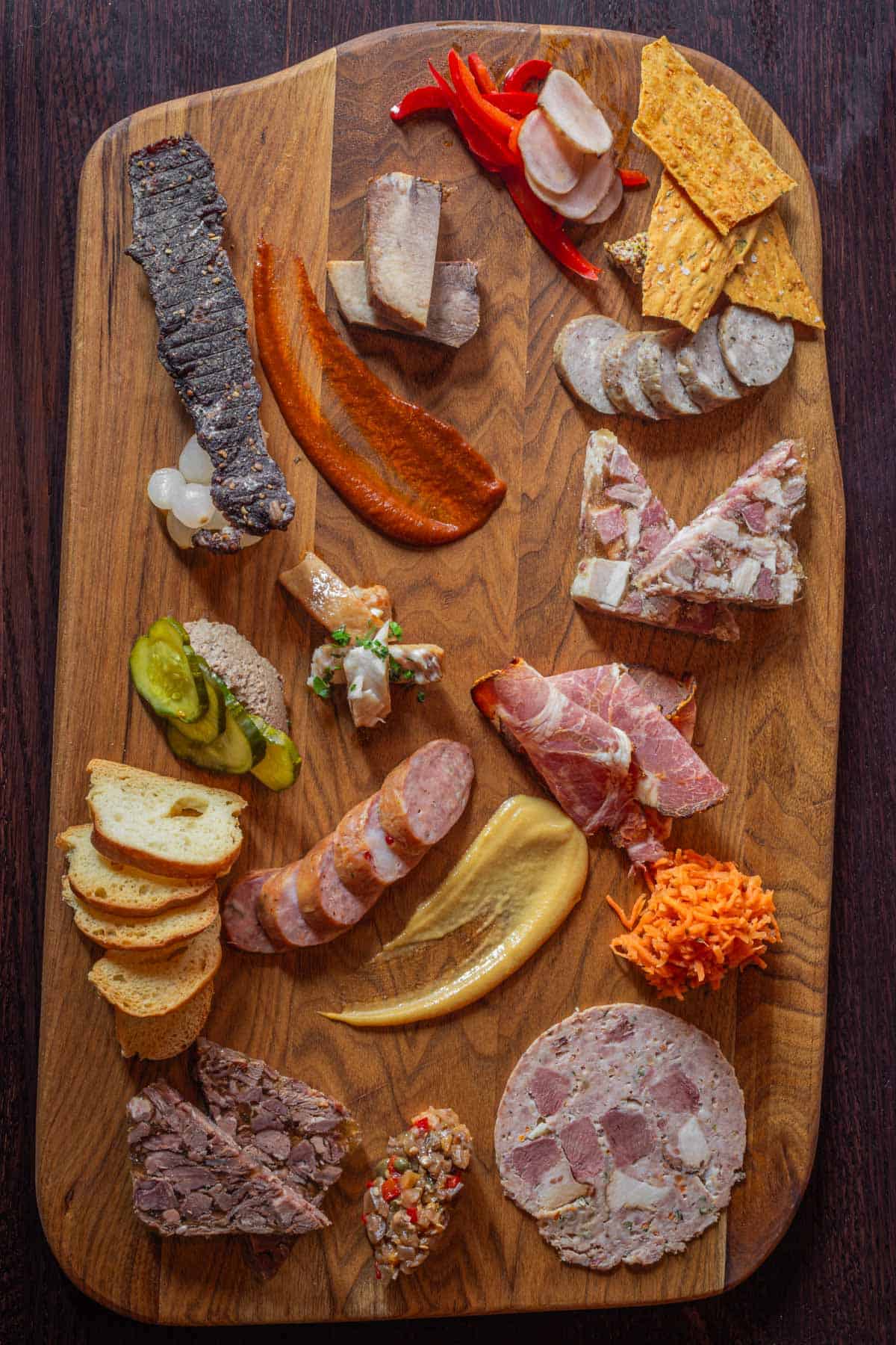 A large charcuterie board of all homemade charcuterie including headcheese. 