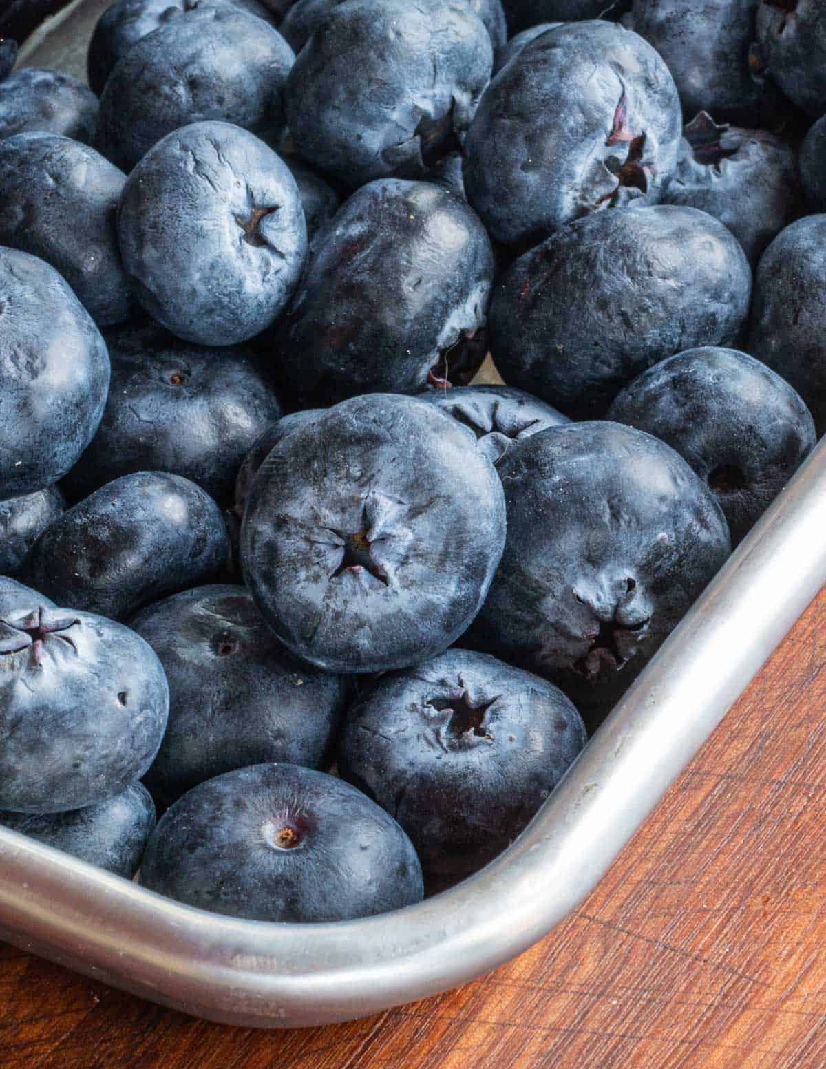 Cultivated blueberries on a baking sheet.