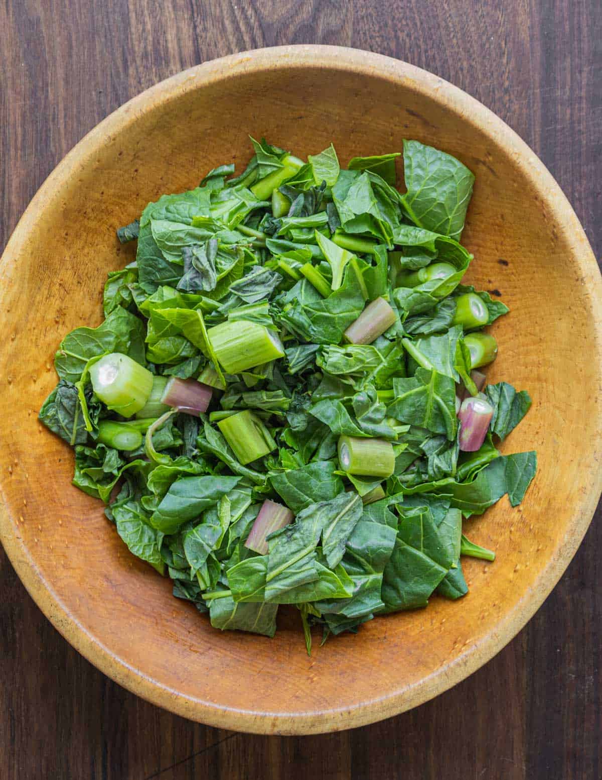 A bowl of cut up poke greens and stems.