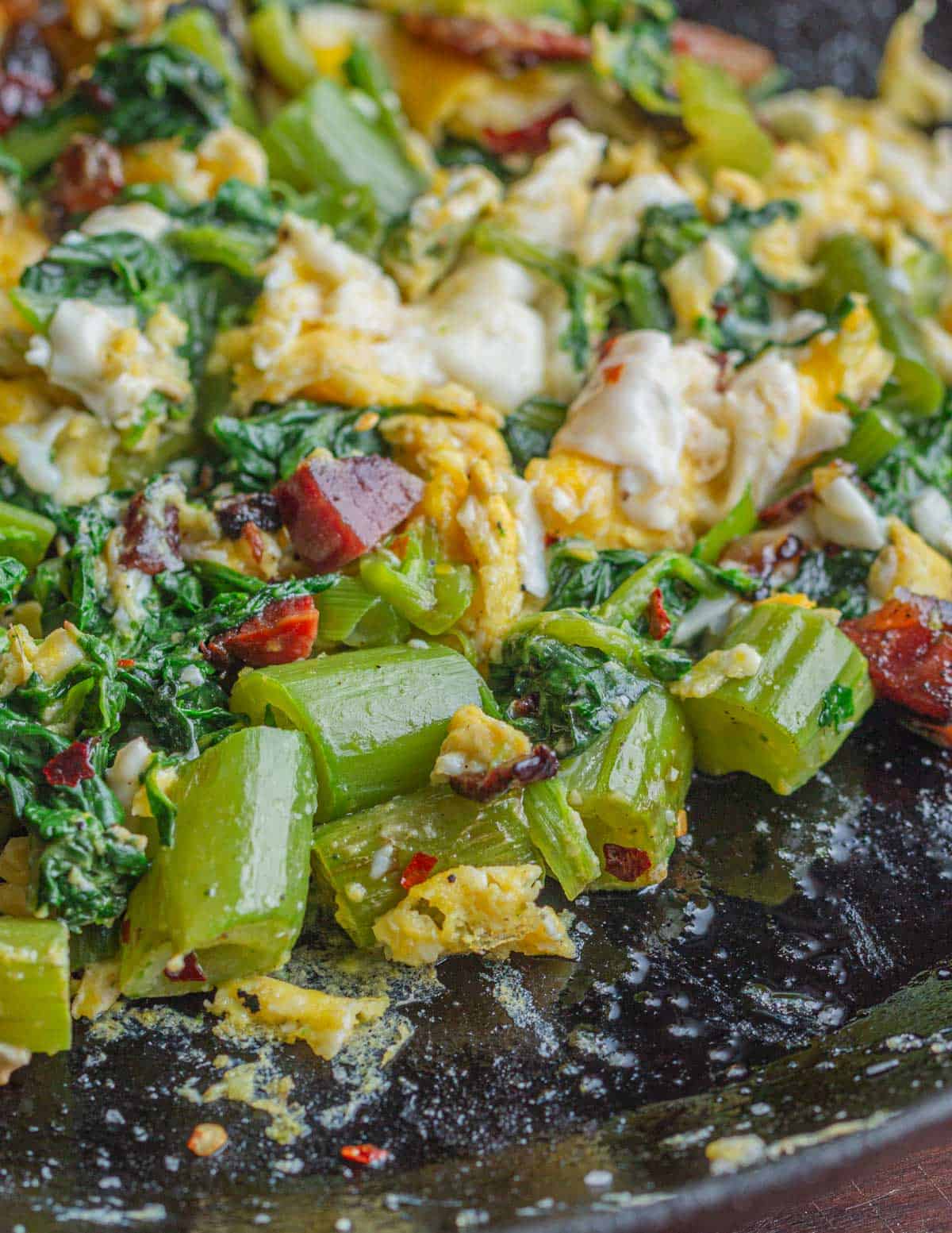 A pan of cooked polk salad with eggs and bacon. 