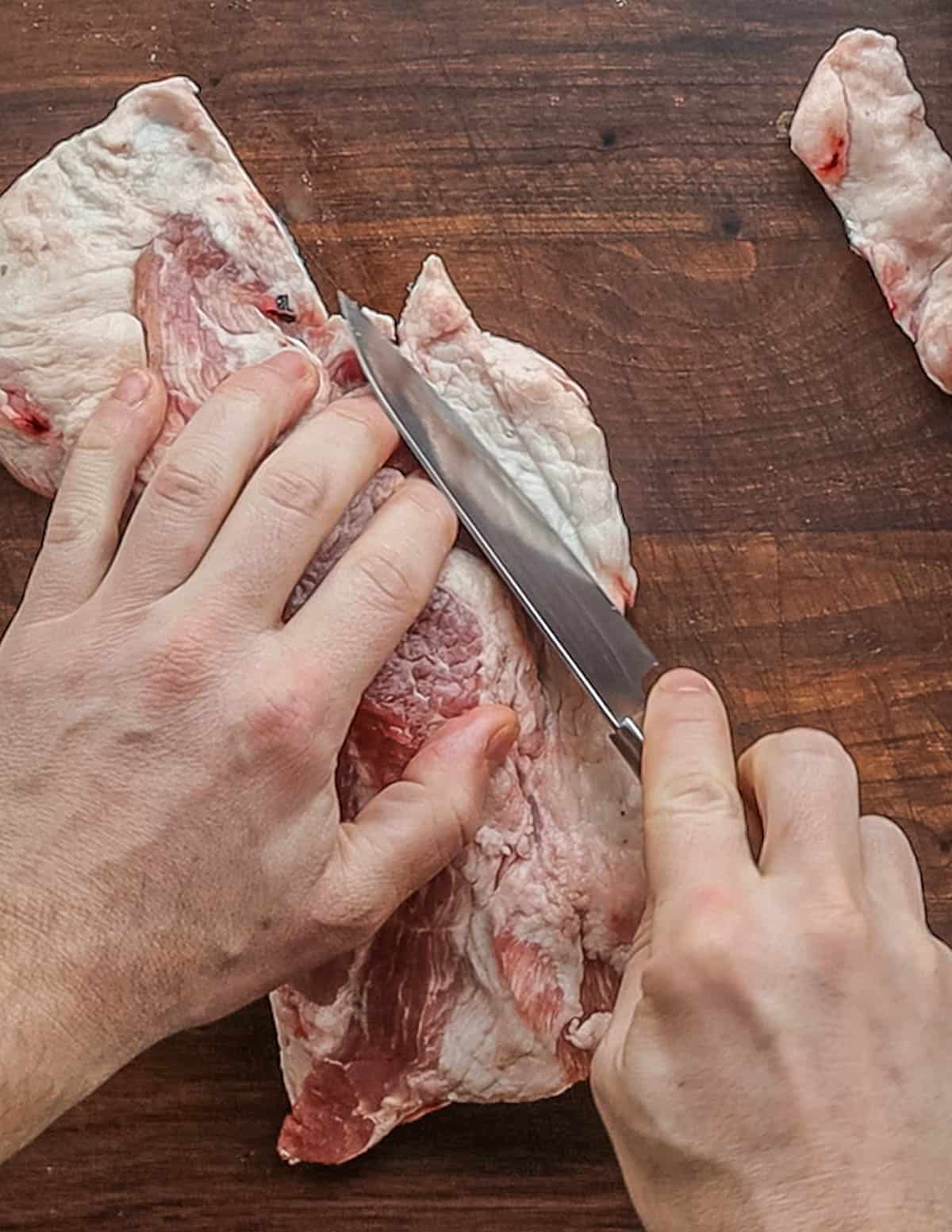 Trimming excess fat from a pork brisket. 