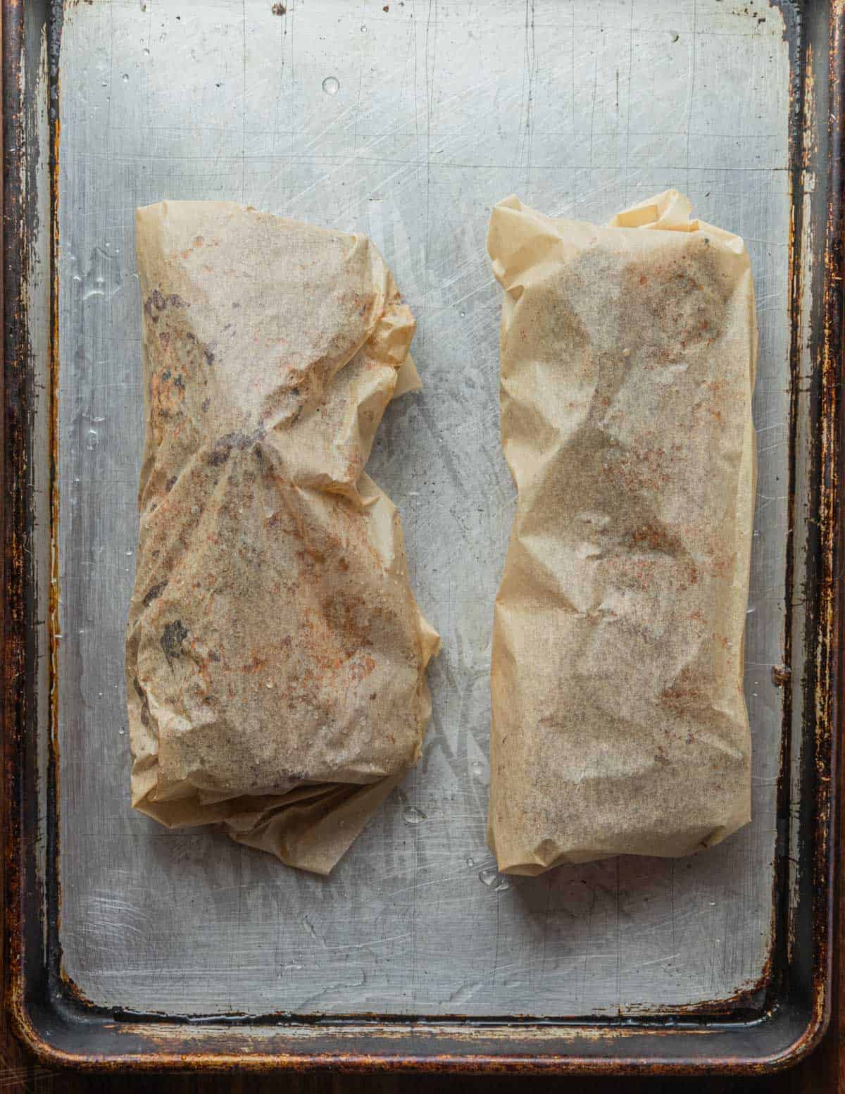Smoked pork briskets wrapped in parchment paper. 