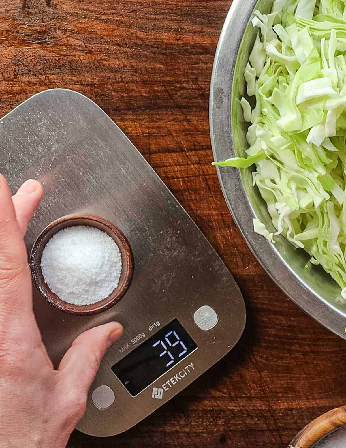 Weighing out the correct amount of salt for sauerkraut using a scale. 
