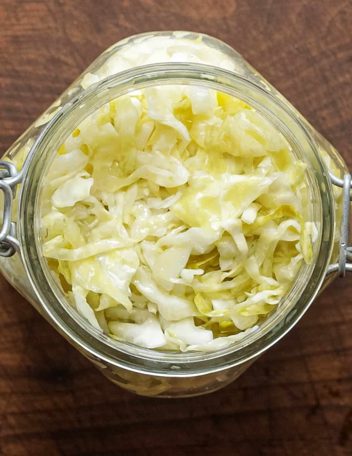 Sauerkraut cabbage being placed in a jar after fermenting. 