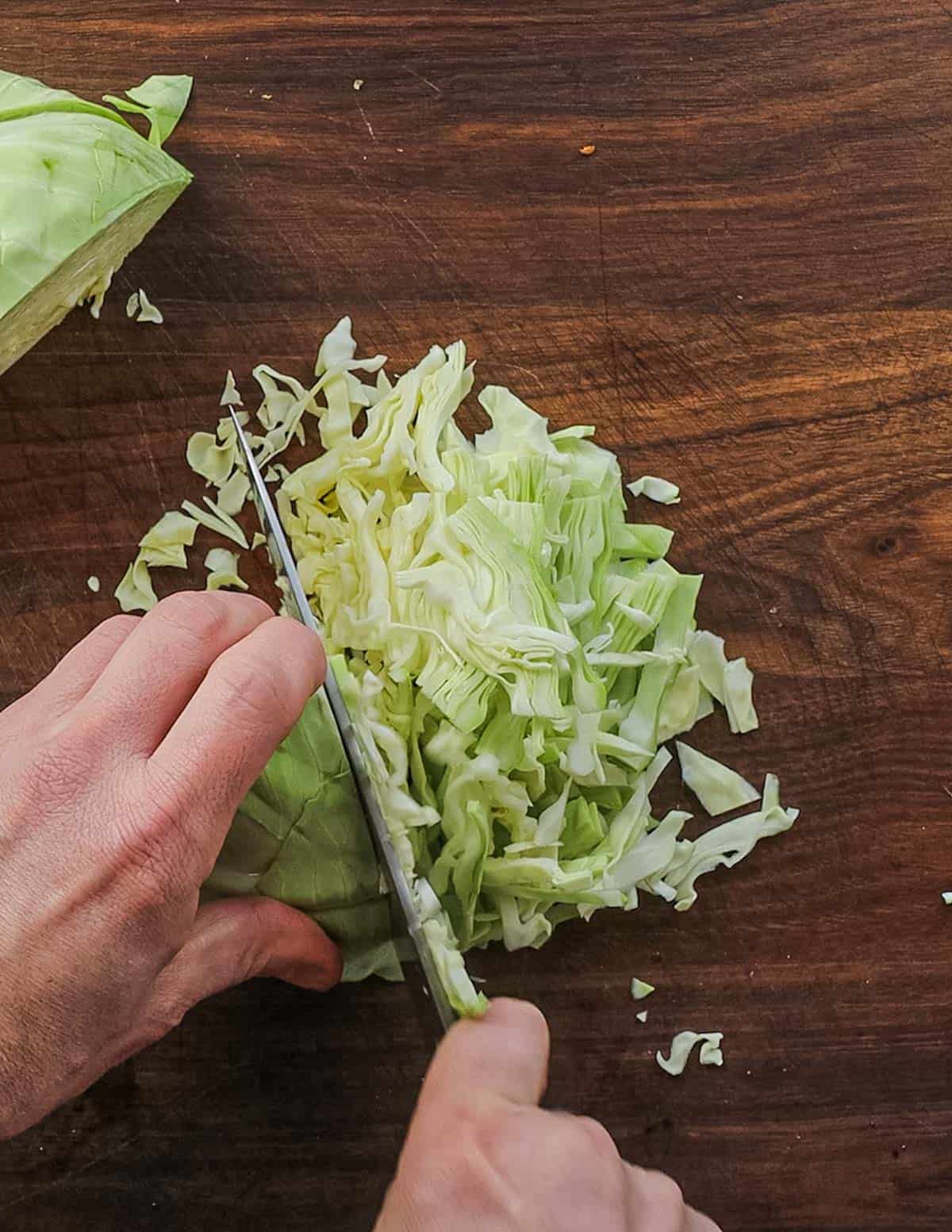 Shredding cabbages for sauerkraut using a chefs knife. 